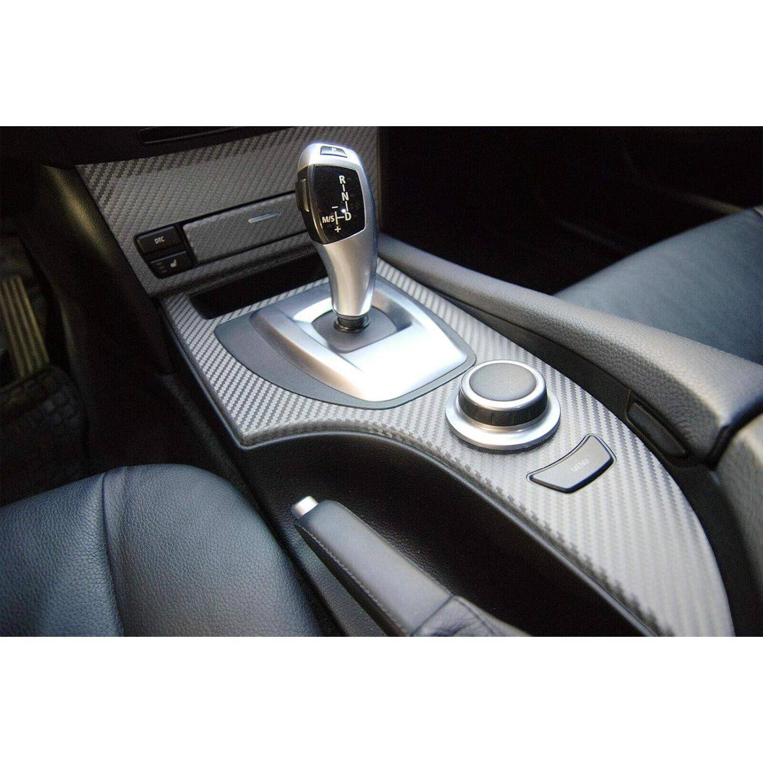 Mittelkonsole des Autos mit automatischem Schaltgestänge, Drehreglern und Kohlefaser-optik-Verkleidung zwischen den Vordersitzen.