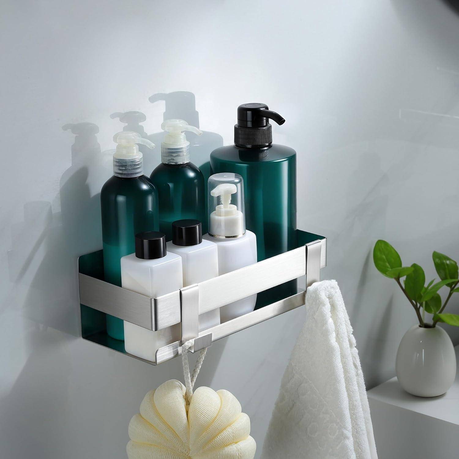 Badezimmerwandregal mit grünen und weißen Toilettenflaschen, mit einem hängenden weißen Handtuch und einer kleinen Topfpflanze in der Nähe.