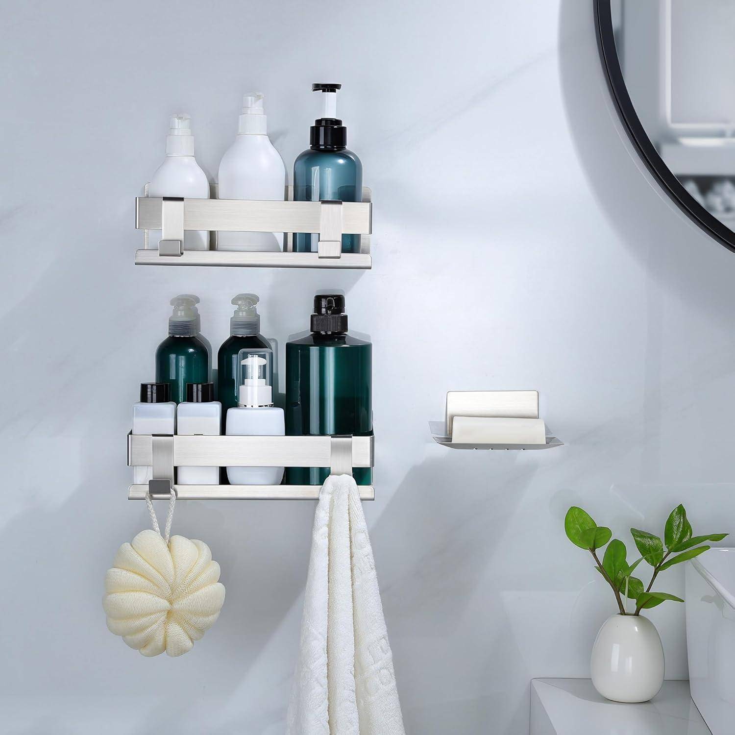Badezimmer-Wandregale, auf denen Shampoo- und Seifenflaschen stehen, mit hängendem Handtuch und Badeschwamm neben einer kleinen Pflanze an einer sauberen weißen Wand.