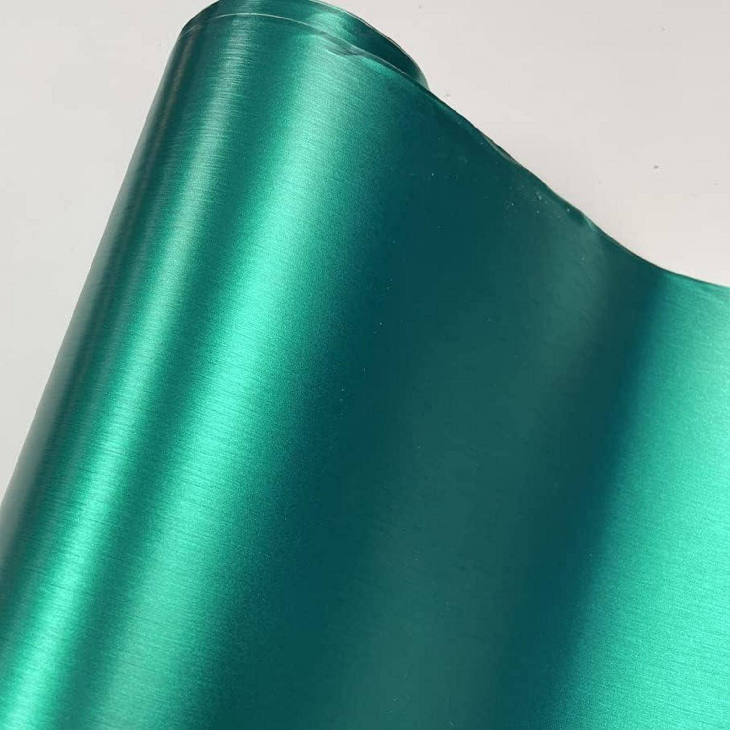 Glänzendes blaugrünes Metallblech mit einer glatten, gewölbten Oberfläche vor hellem Hintergrund.