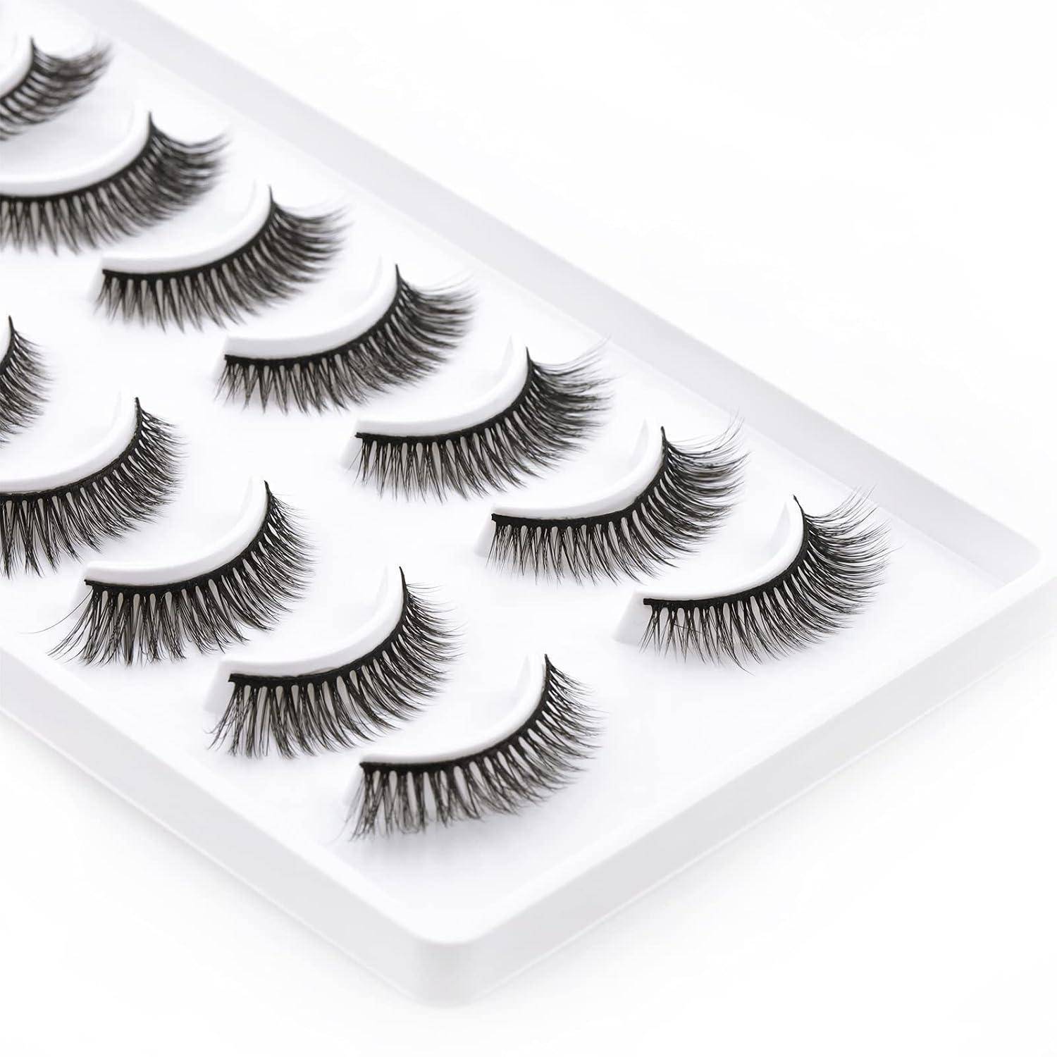 Tablett mit künstlichen Wimpern, die in Reihen auf einem weißen Präsentationsständer angeordnet sind und mehrere Stile und Längen zeigen.