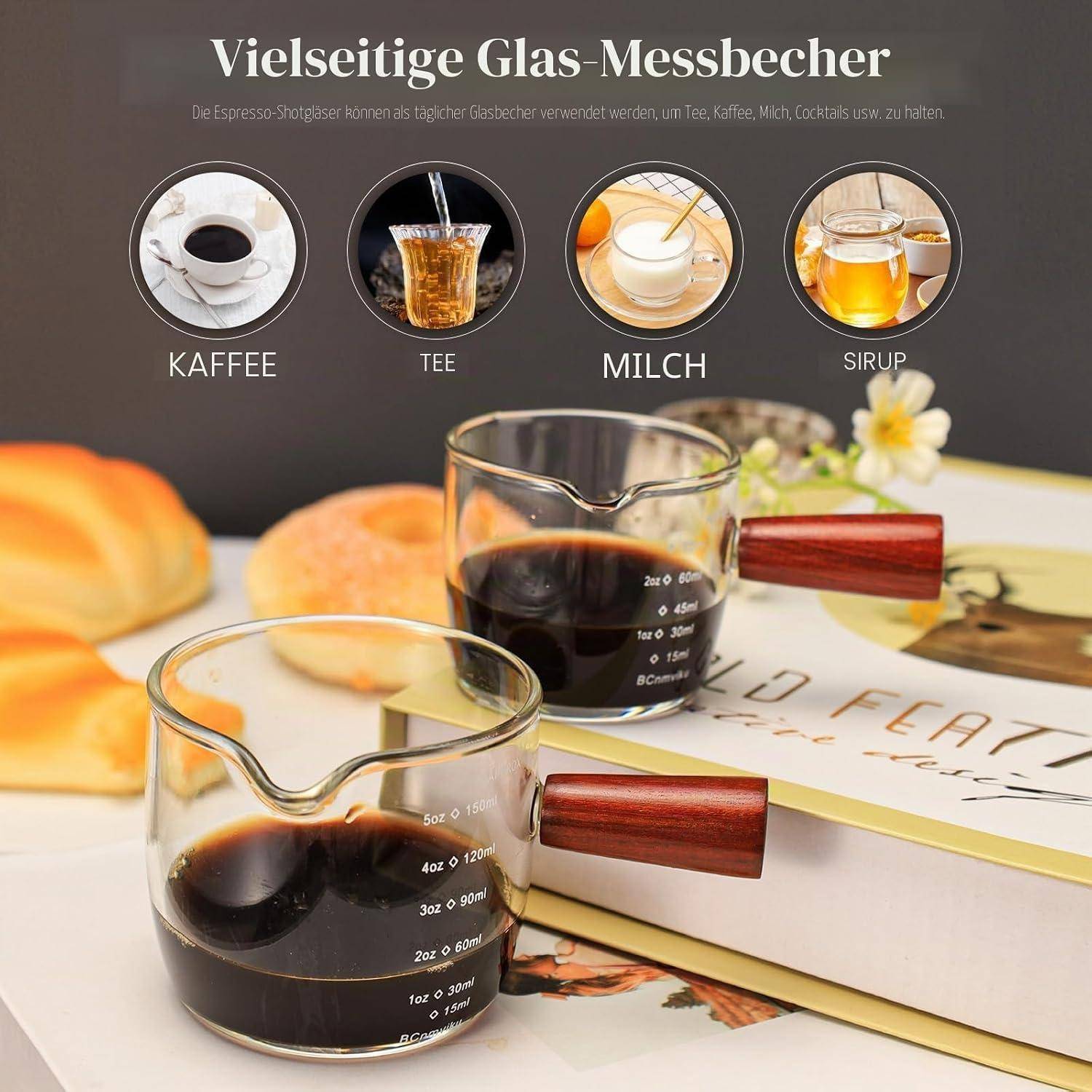 Glaskaffeemessbecher mit Holzgriffen für Kaffee, Tee, Milch und Sirup, gezeigt mit Etiketten und gefüllt mit dunkler Flüssigkeit und Tee.