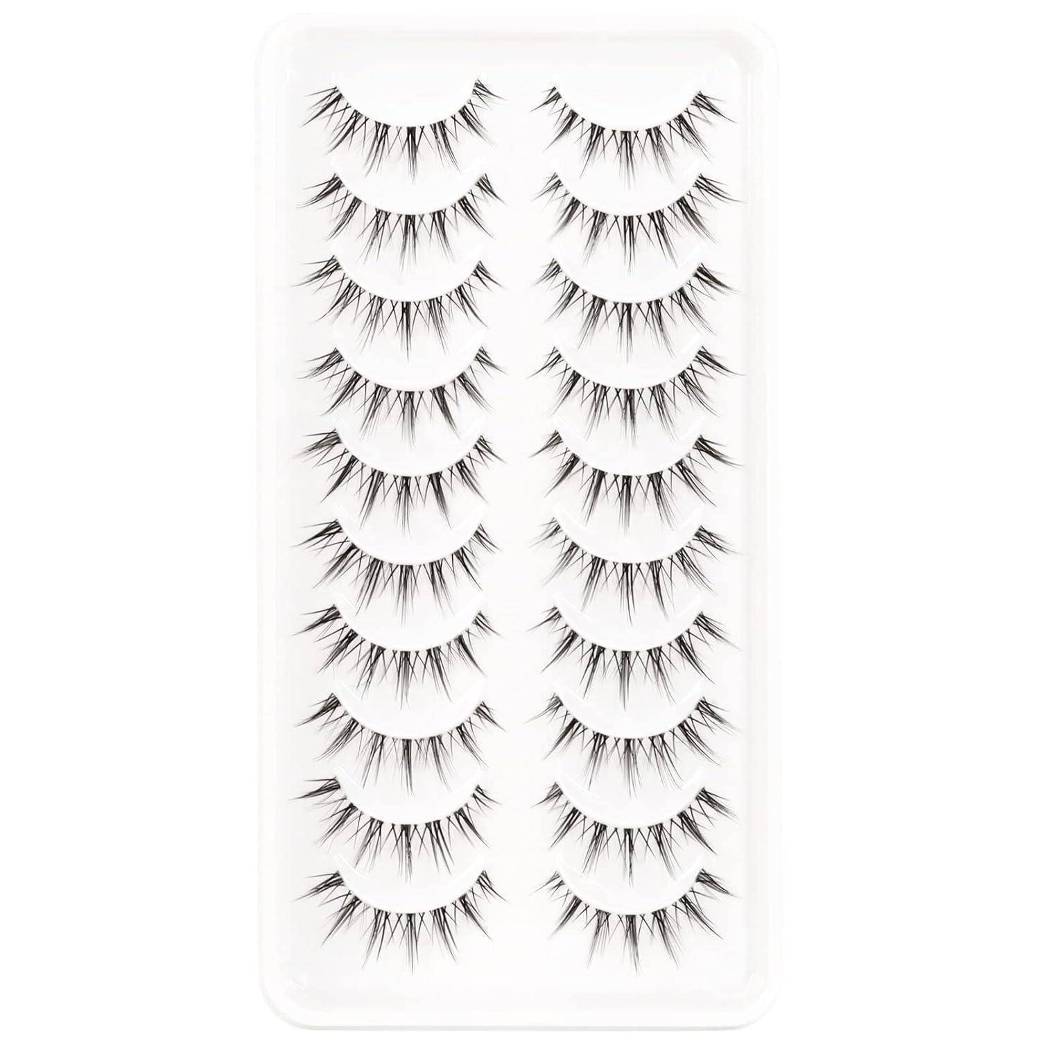 Ein durchsichtiges Kunststoff-Tablett enthält einen Satz künstlicher Wimpern in zwei senkrechten Spalten, wobei jedes Paar dramatische, stachelige schwarze Wimpernstile zeigt.