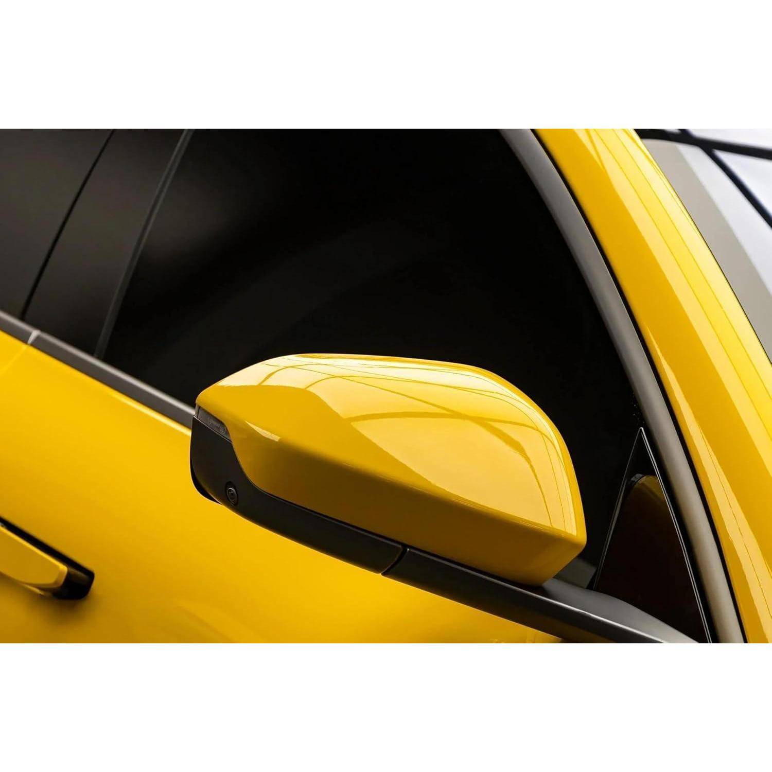 Nahaufnahme des Seitenspiegels und Türrahmens eines gelben Autos, die die glänzende Außenoberfläche und das getönte Fenster zeigen.