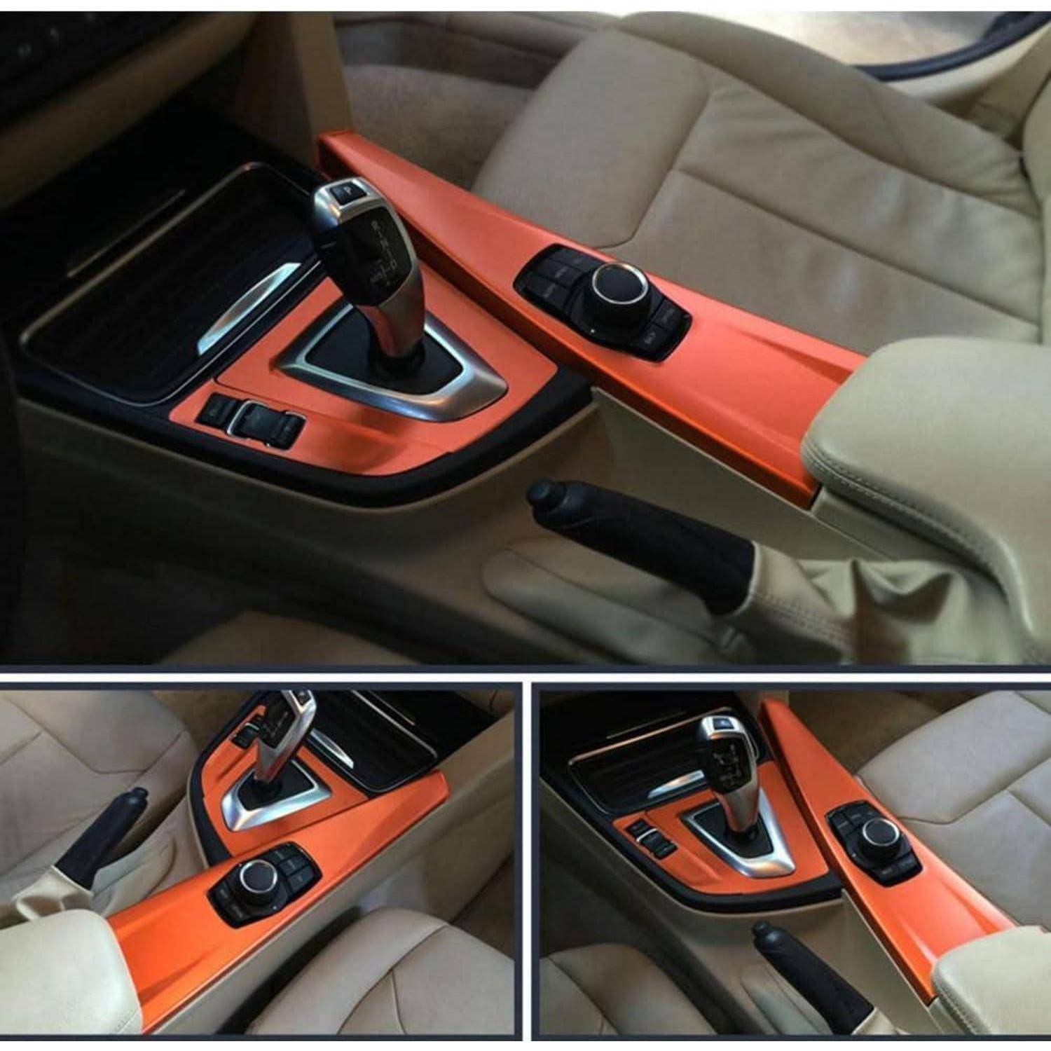 Autoinnenraum-Mitttelkonsole mit leuchtend orangefarbener Blende, automatischer Gangwahlschalter, Drehregelknopf und Handbremse, dargestellt aus mehreren Blickwinkeln.