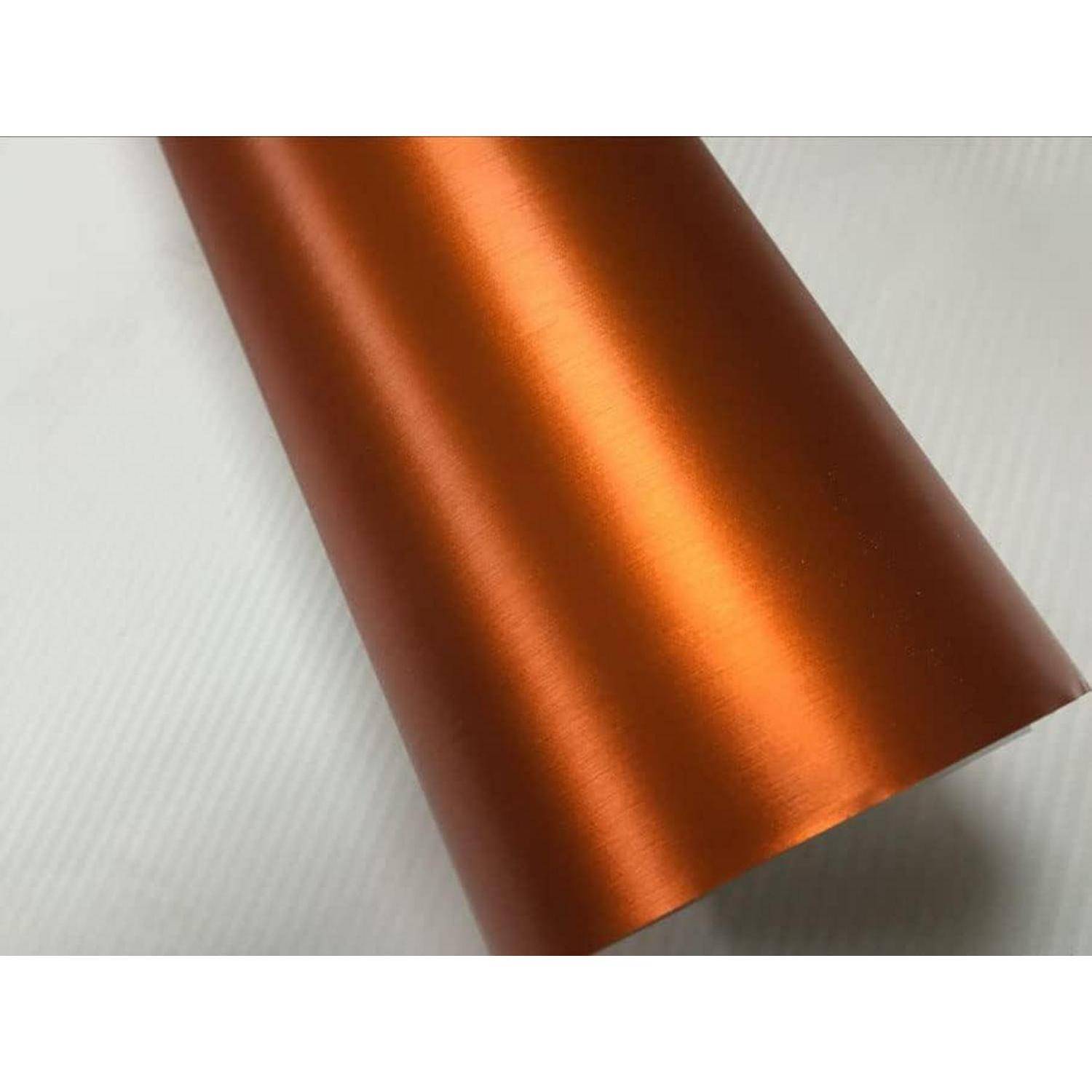 Nahaufnahme einer aufgerollten Folie aus glänzendem, metallischem kupfer-orangefarbenem Material auf einer hell strukturierten Oberfläche.