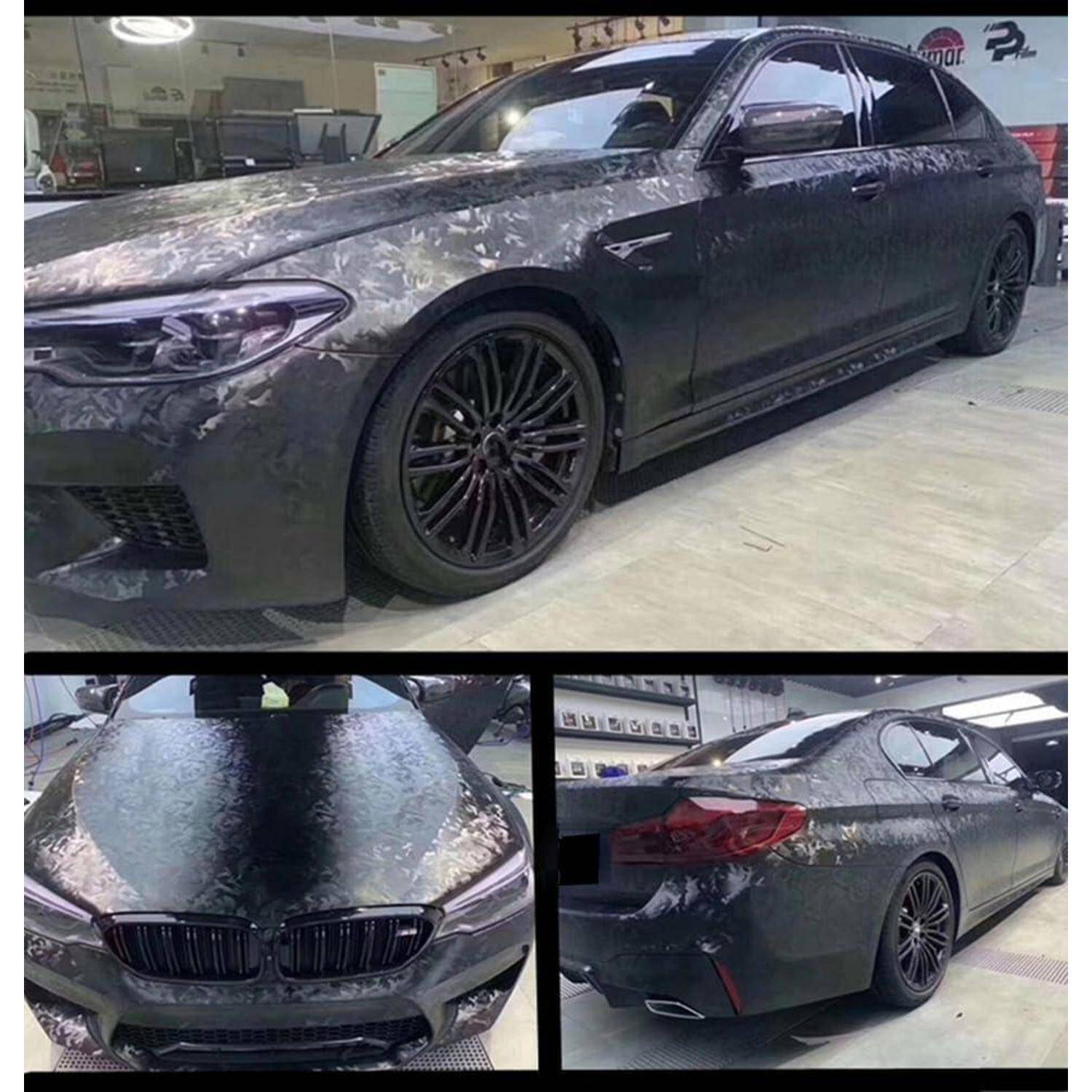 Ein schwarzer BMW-Limousine in einer Werkstatt, in einem grauen Tarnmuster verpackt, von vorne, von der Seite und von hinten gezeigt.