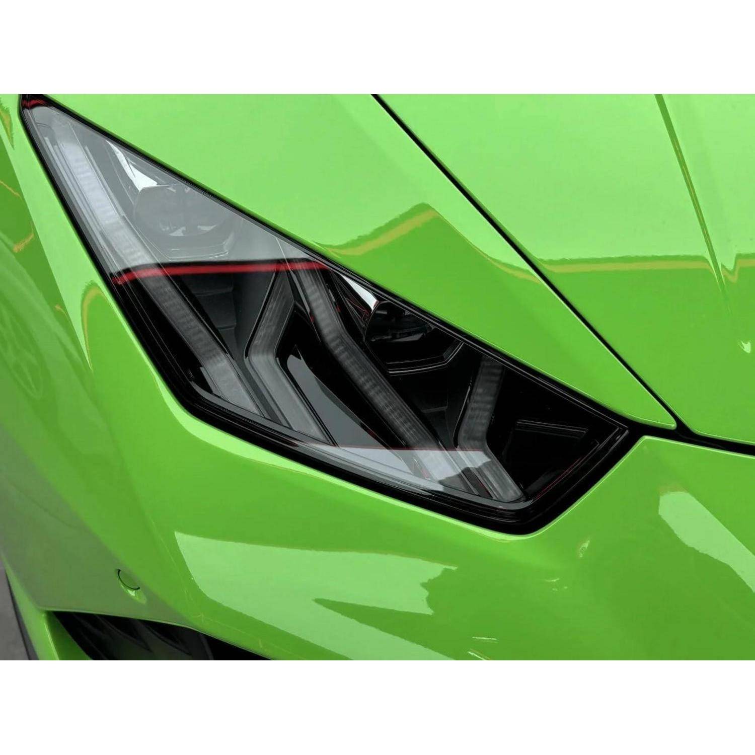 Nahaufnahme des eckigen Scheinwerfers und der Motorhaube eines leuchtend grünen Sportwagens.