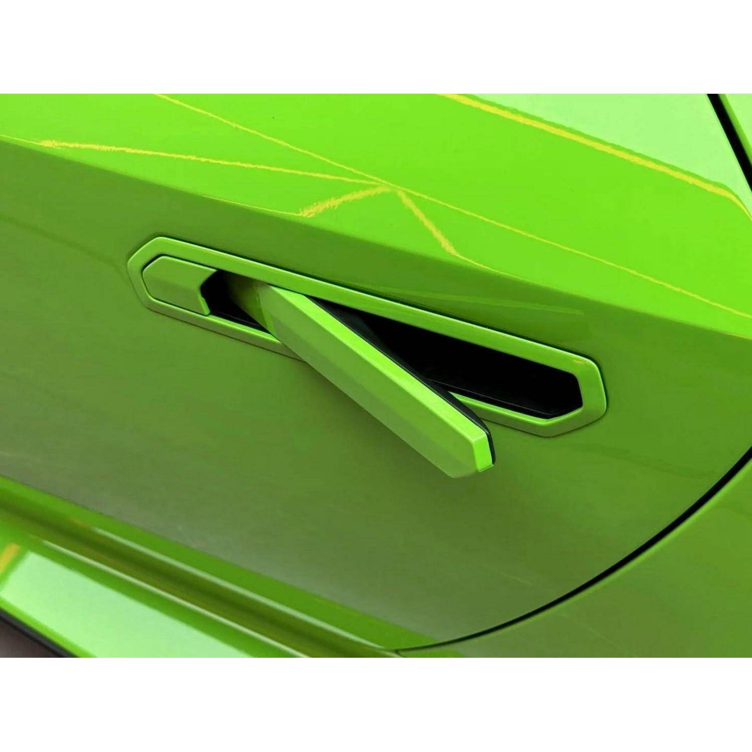 Nahaufnahme des ausgefahrenen, verborgenen Türgriffs eines leuchtend grünen Autos, der aus der Türverkleidung herausragt.