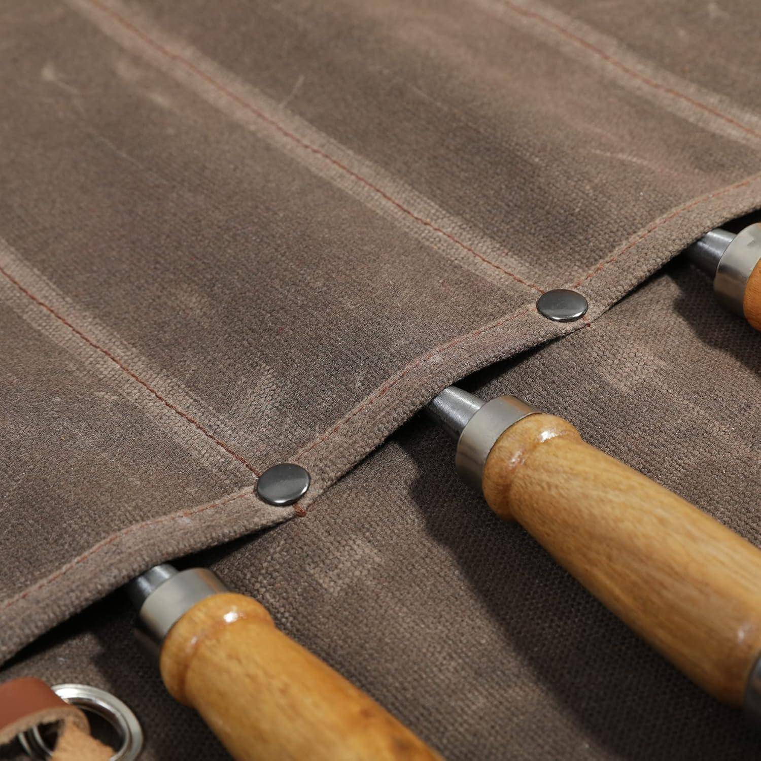 Nahaufnahme einer braunen Leinwand-Werkzeugrolle mit Metalldruckknöpfen und teilweise unter der Klappe sichtbaren Werkzeugen mit Holzgriffen.