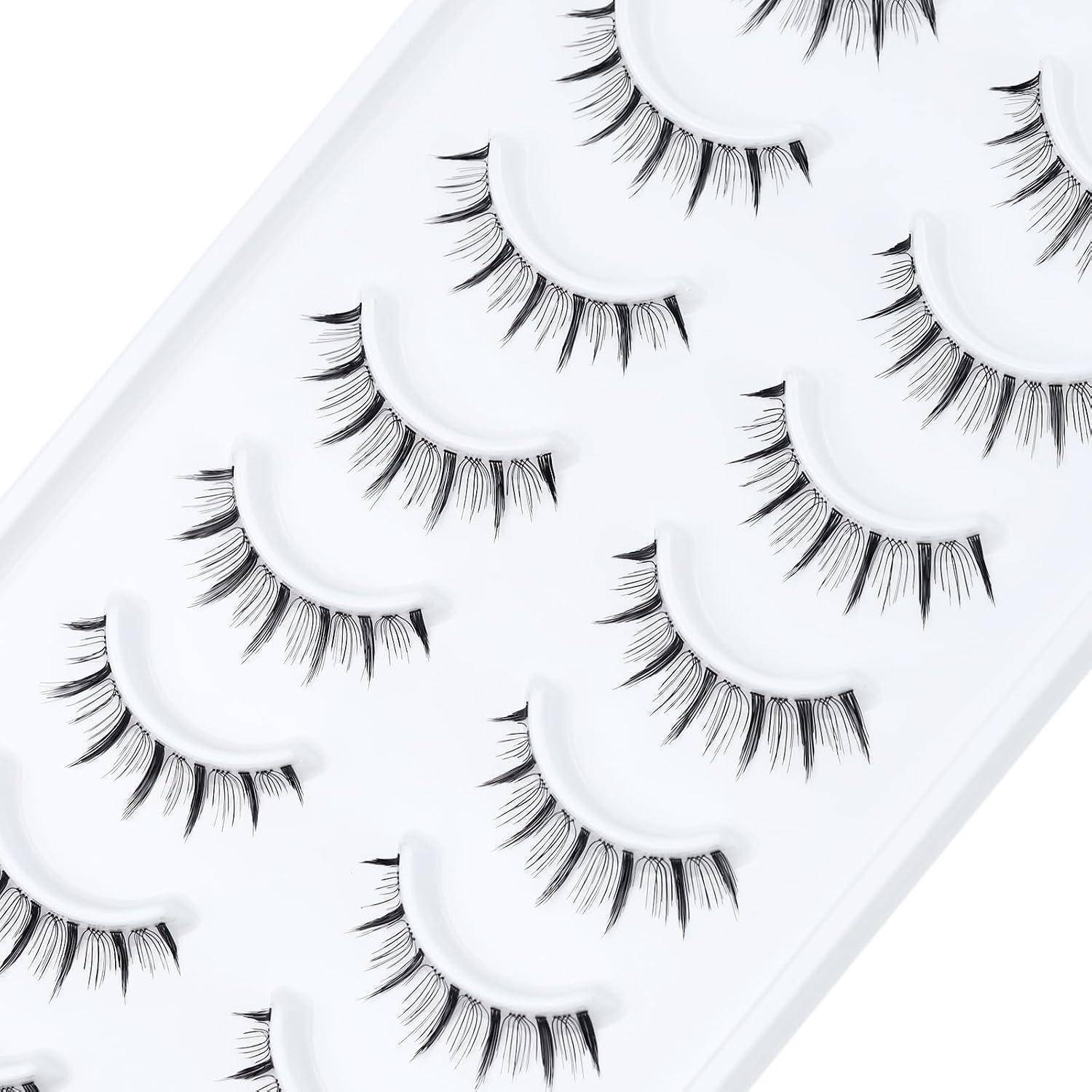 Tablett mit künstlichen Wimpern in Reihen auf weißem Untergrund angeordnet