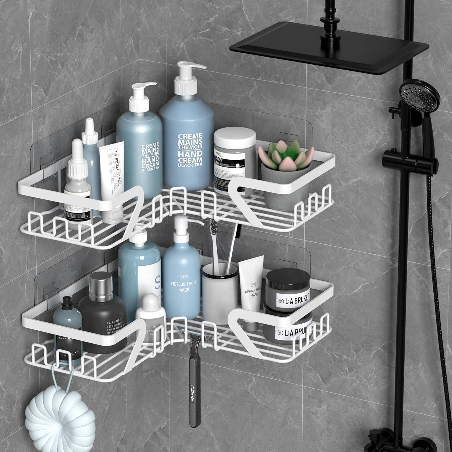 Eckablage für die Dusche mit weißen Drahtregalen, auf denen Toilettenartikel, Flaschen, Rasierer und Seife auf einer graufliesenbedeckten Wand neben einer Duschkopf und schwarzer Duscharmatur angeordnet sind.