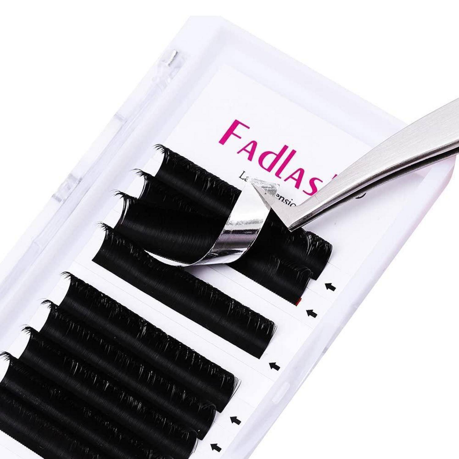 Eine Pinzette schält einen Streifen schwarzer künstlicher Wimpern von einem weißen FadLash-Tablett-Paket ab.