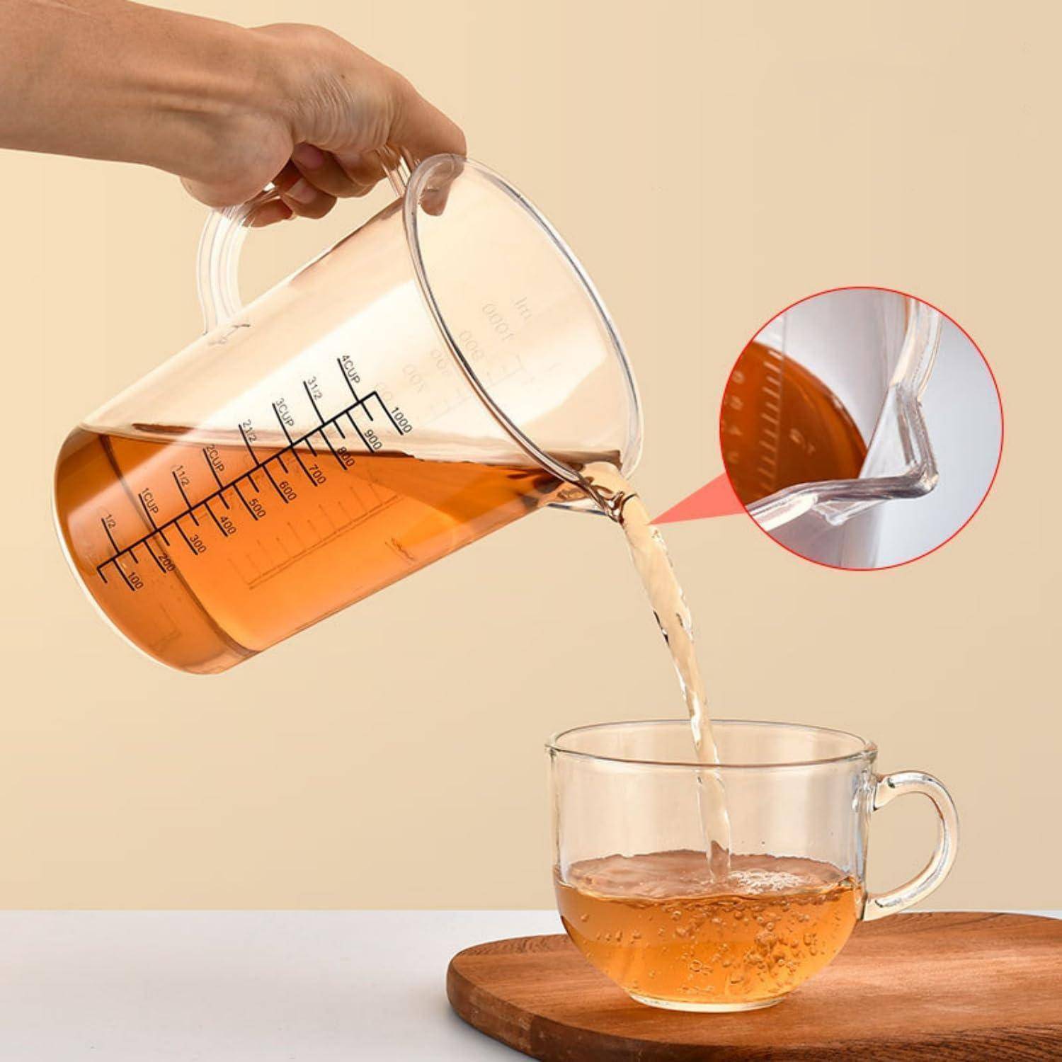 Eine Hand gießt bernsteinfarbenen Tee aus einem Glaskrug in eine durchsichtige Tasse, wobei ein vergrößertes Inset die Ausgießöffnung des Krugs hervorhebt.