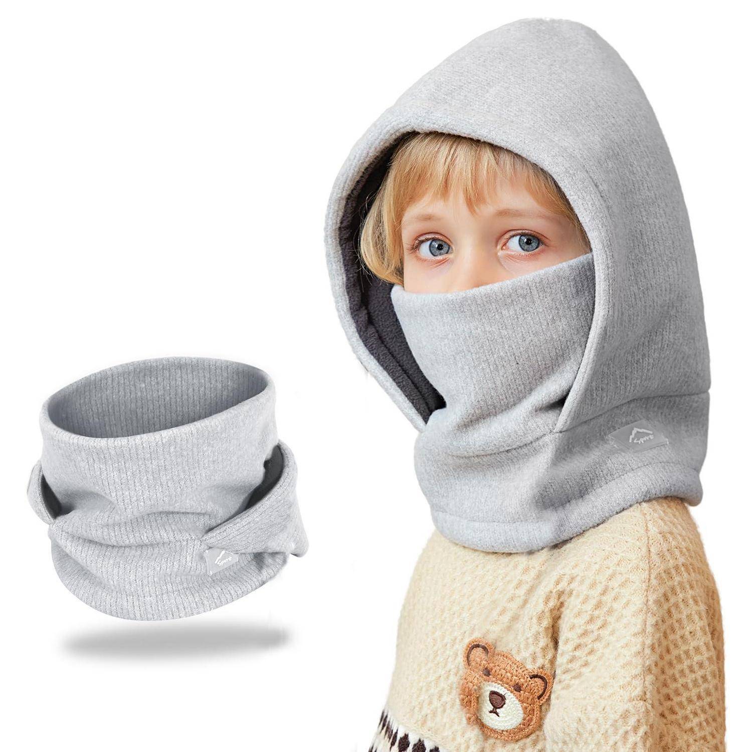 Kind, das eine graue Kapuzengesichtsmaske und einen Halswärmer trägt, mit einem separaten passenden Halsschal daneben gezeigt.