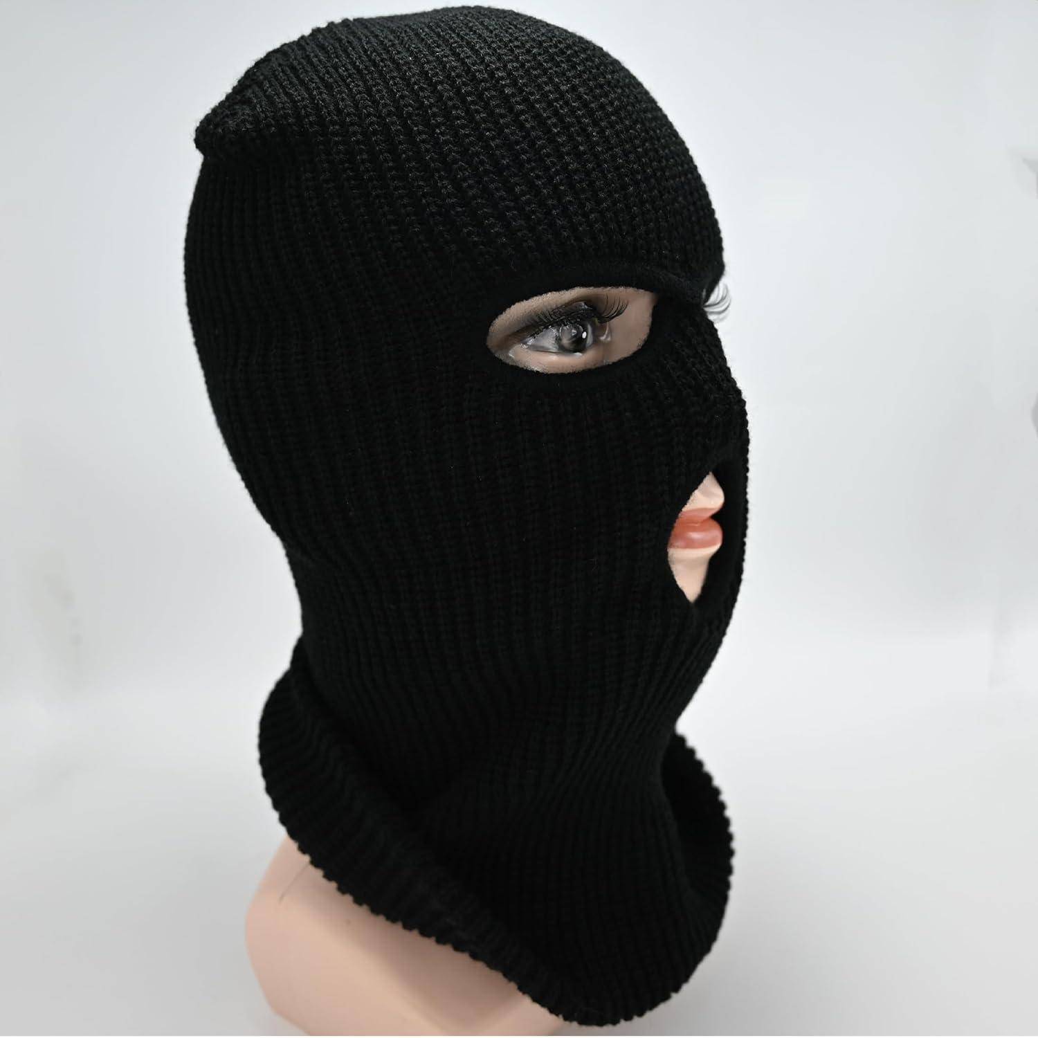 Schwarze gestrickte Sturmhaube, die einen Schaufensterkopf bedeckt, mit Öffnungen für ein Auge und den Mund auf einem einfachen helleren Hintergrund.