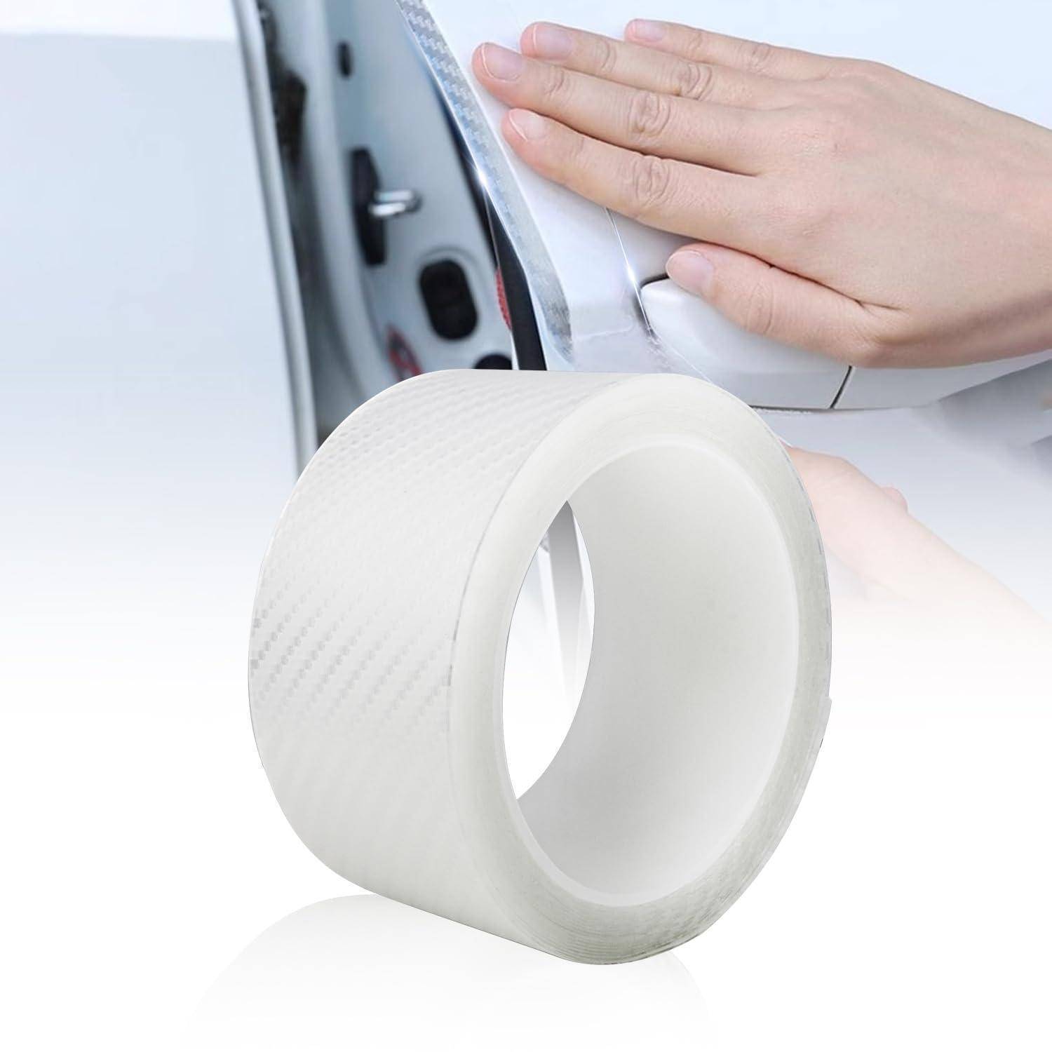 Eine Hand, die transparente Schutzfolie auf einer Autotür glättet, mit einer Rolle Klebeband im Vordergrund.