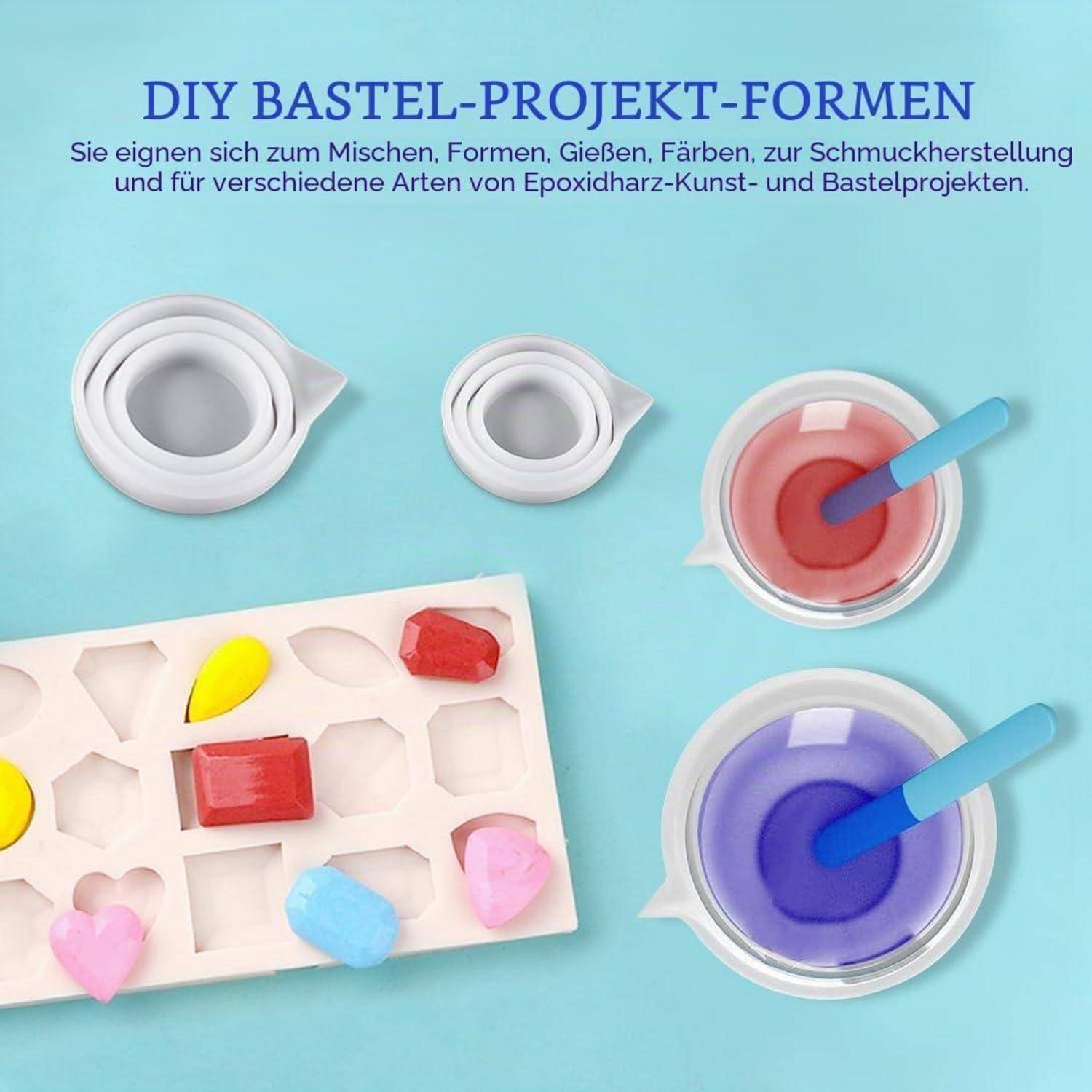 DIY-Handwerksprojekt-Formen für Harz und Schmuckherstellung, dargestellt mit Silikonbechern, gemischten Harzfarben und fertigen Herz- und Edelsteinstücken auf blauem Hintergrund.