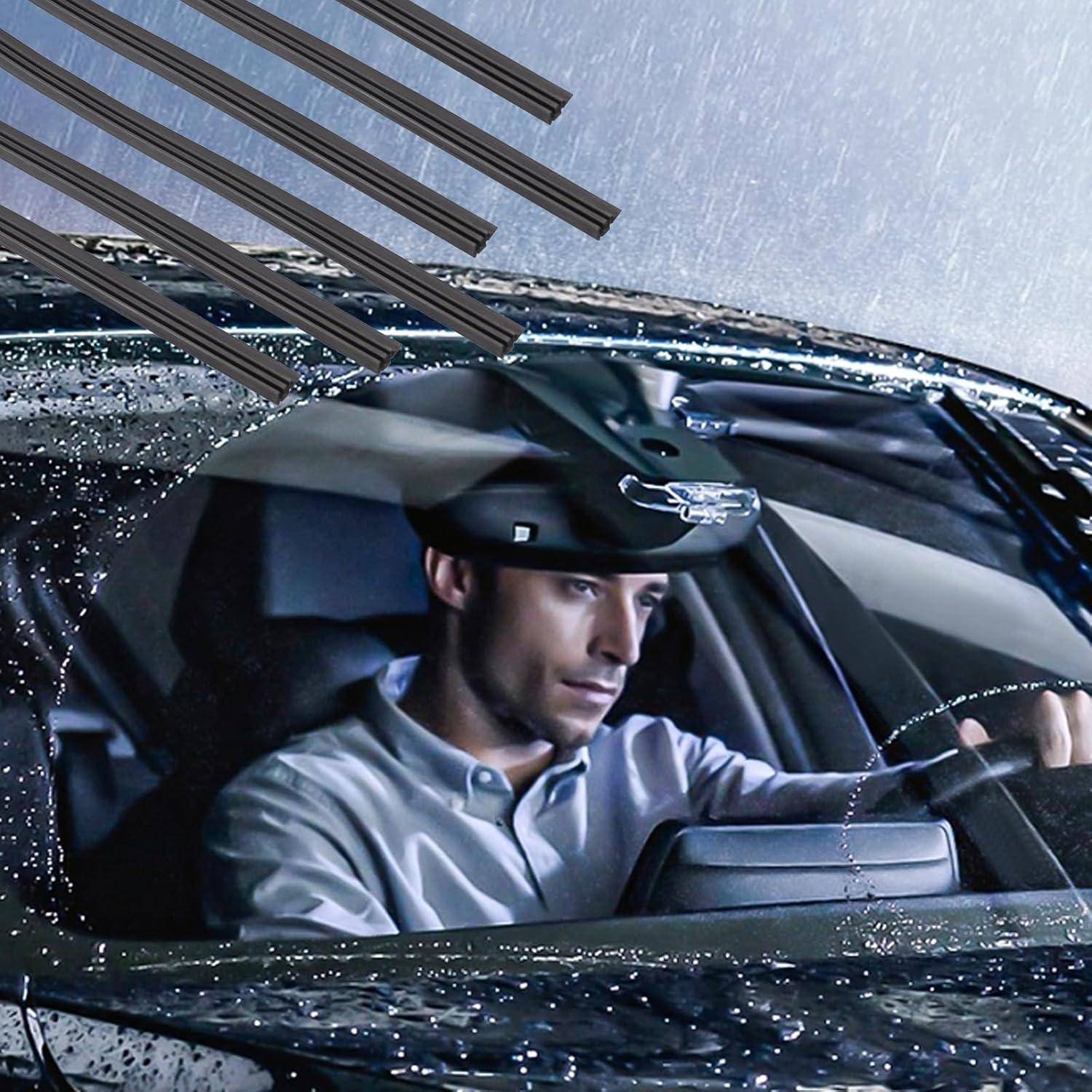 Ein Fahrer mit schwarzem Hut sitzt bei starkem Regen in einem Auto, gesehen durch eine nasse Windschutzscheibe.