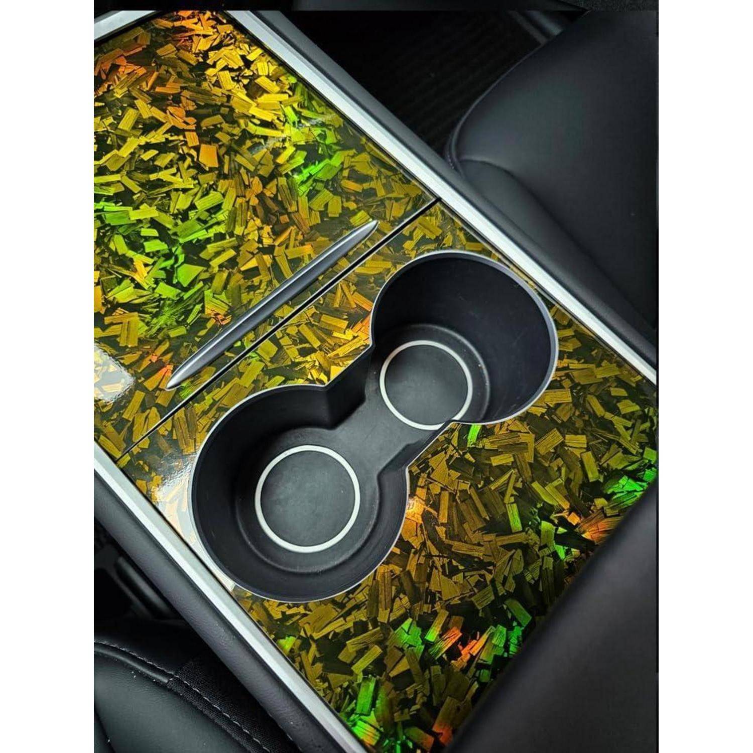 Mittenkonsole des Autos mit einer leeren doppelten Getränkehalter-Aussparung in einem hochglänzenden Trimmblech mit Gold-und-Grün-Muster.