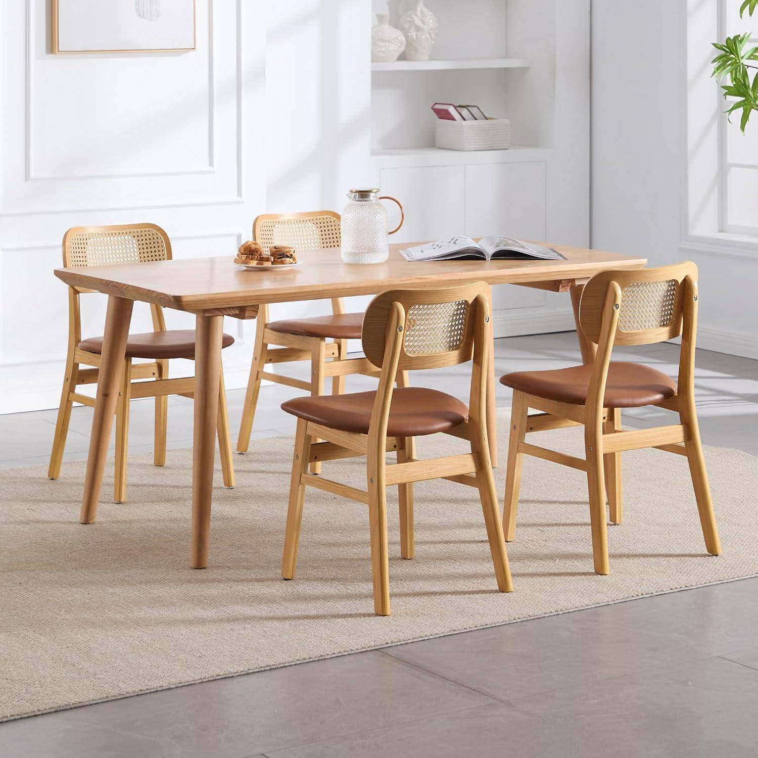 Heller Holzesstisch mit vier passenden Stühlen in einem hellen, minimalistischen Raum; die Tischplatte trägt einen Krug, Tassen und ein aufgeschlagenes Buch.