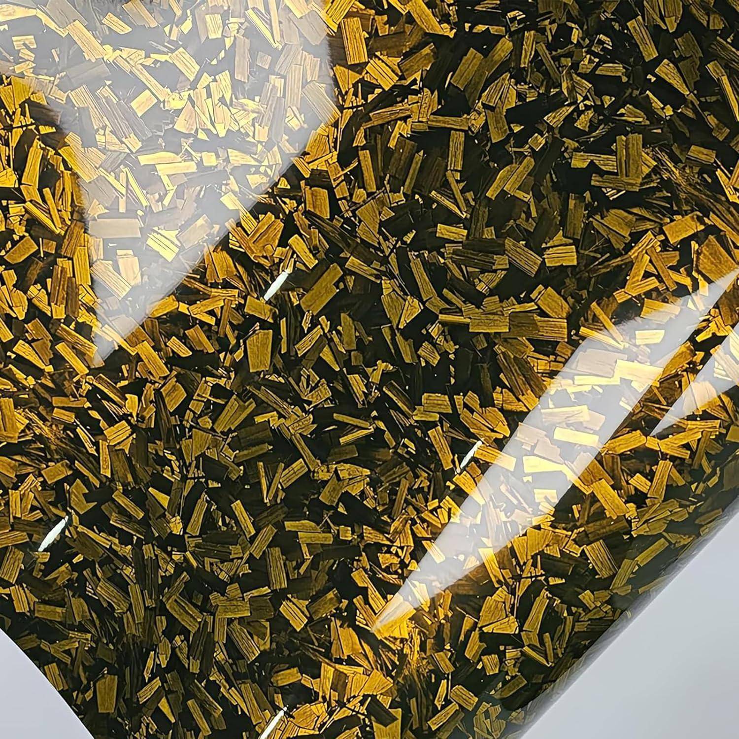 Nahaufnahme eines durchsichtigen Behälters gefüllt mit schwarz-goldenem Glitzerstroh, mit hellen Lichtreflexionen auf der Oberfläche.