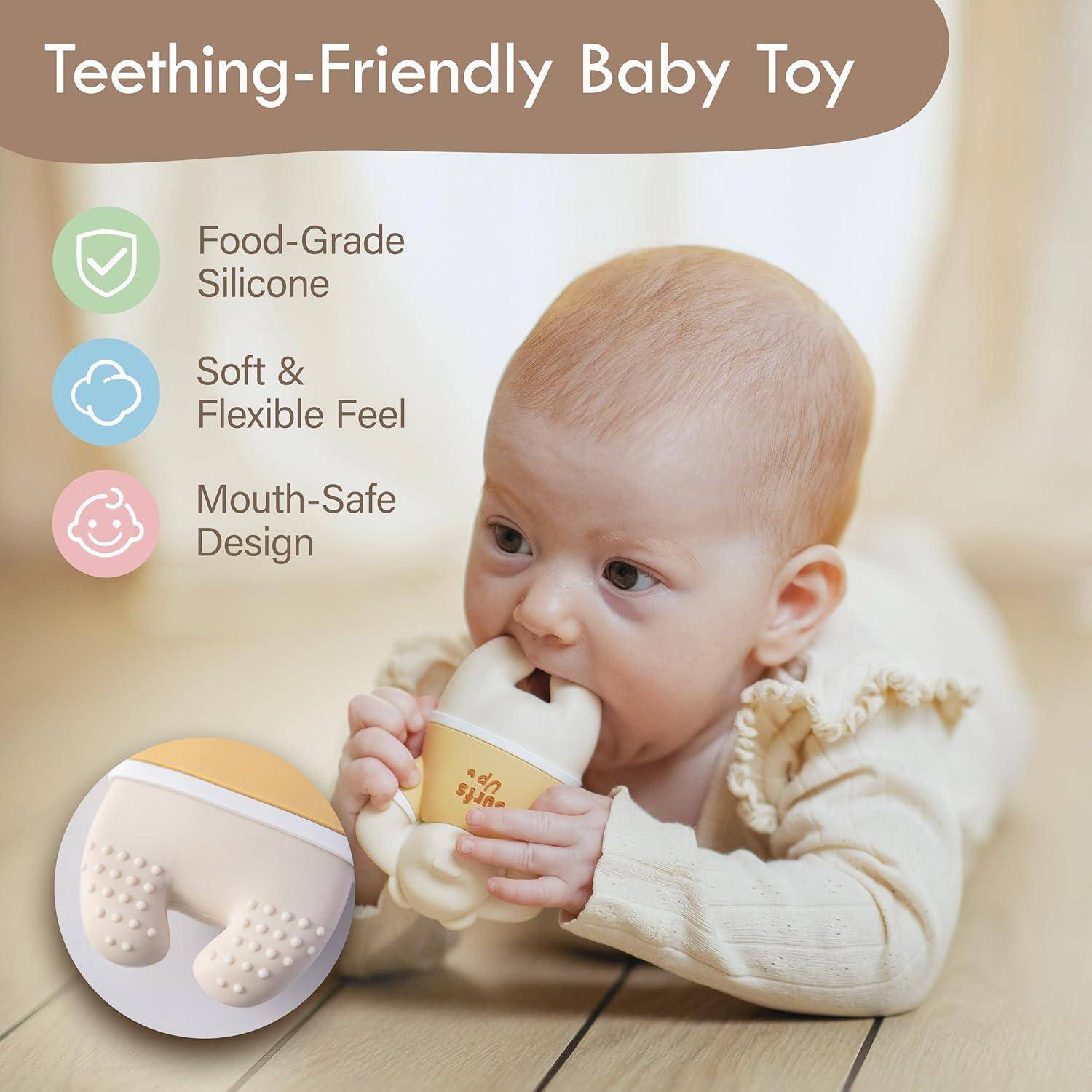 Baby kaut an einem Zahnungsspielzeug, mit Text, der "Zahnungsfreundliches Babyspielzeug"" behauptet, lebensmittelechtes Silikon, weiches und flexibles Gefühl und mundgerechtes Design.