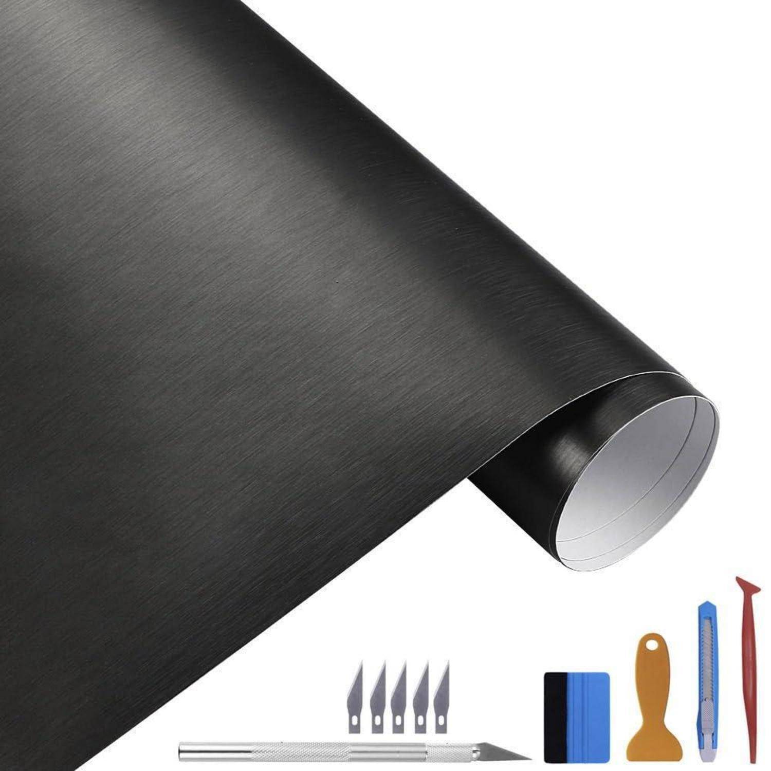 Schwarze Klebstoff-Vinylfolienrolle mit enthaltenem Universalmesser, Klingenpack, Rakel und Kratzer-Werkzeugen auf weißem Hintergrund.