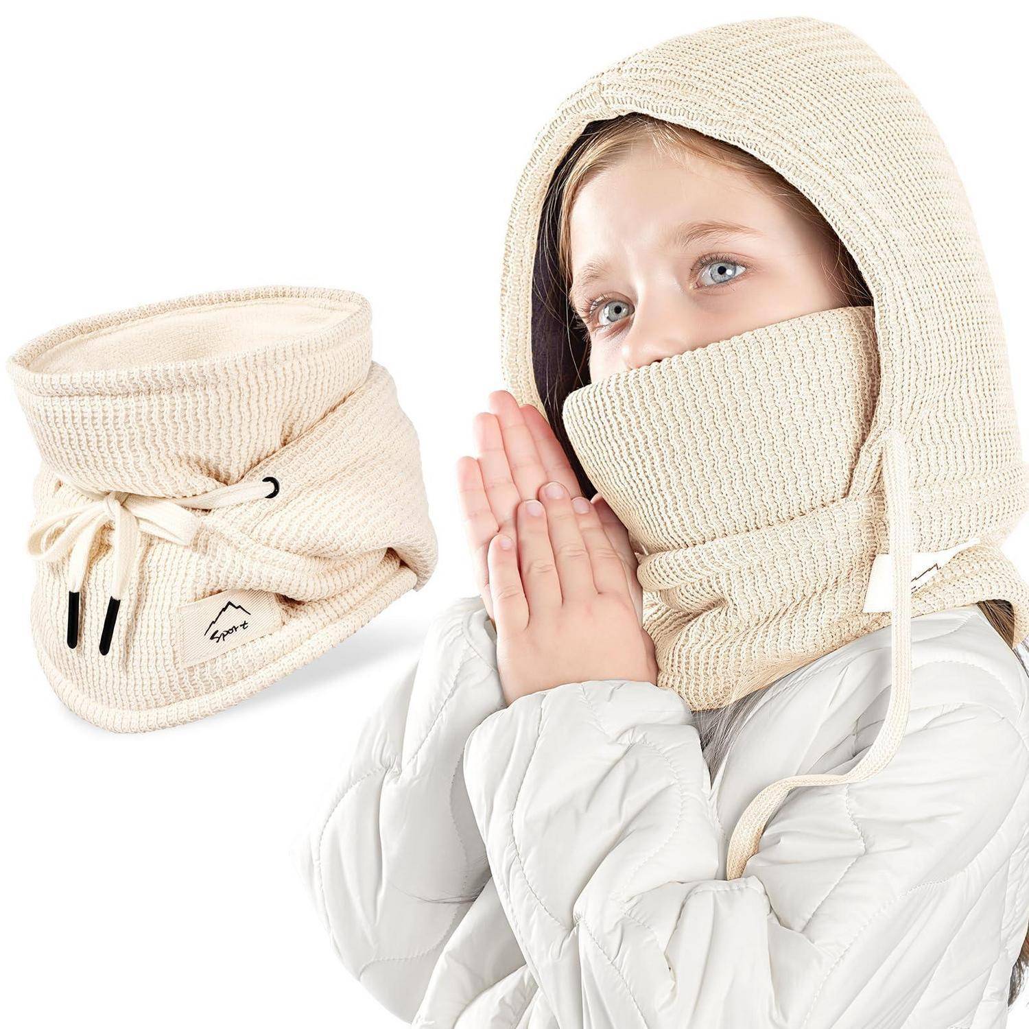 Junges Mädchen in einem weißen Wintermantel und gestricktem Kapuzenschal, mit einem separaten cremefarbenen Halswärmer, der neben ihr gezeigt wird.