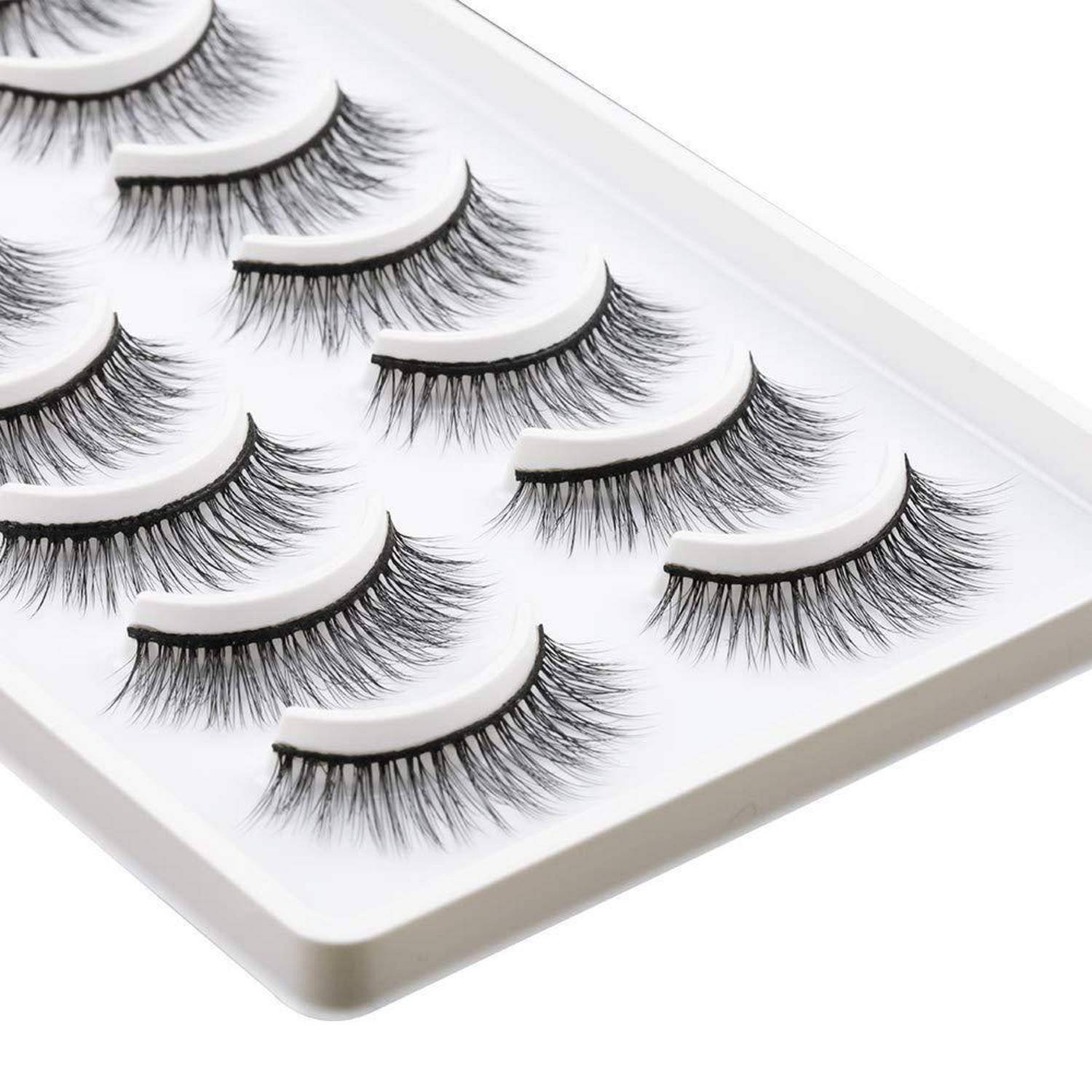 Tablett mit Streifen von künstlichen Wimpern, die in Reihen auf einer weißen Displaykarte angeordnet sind.