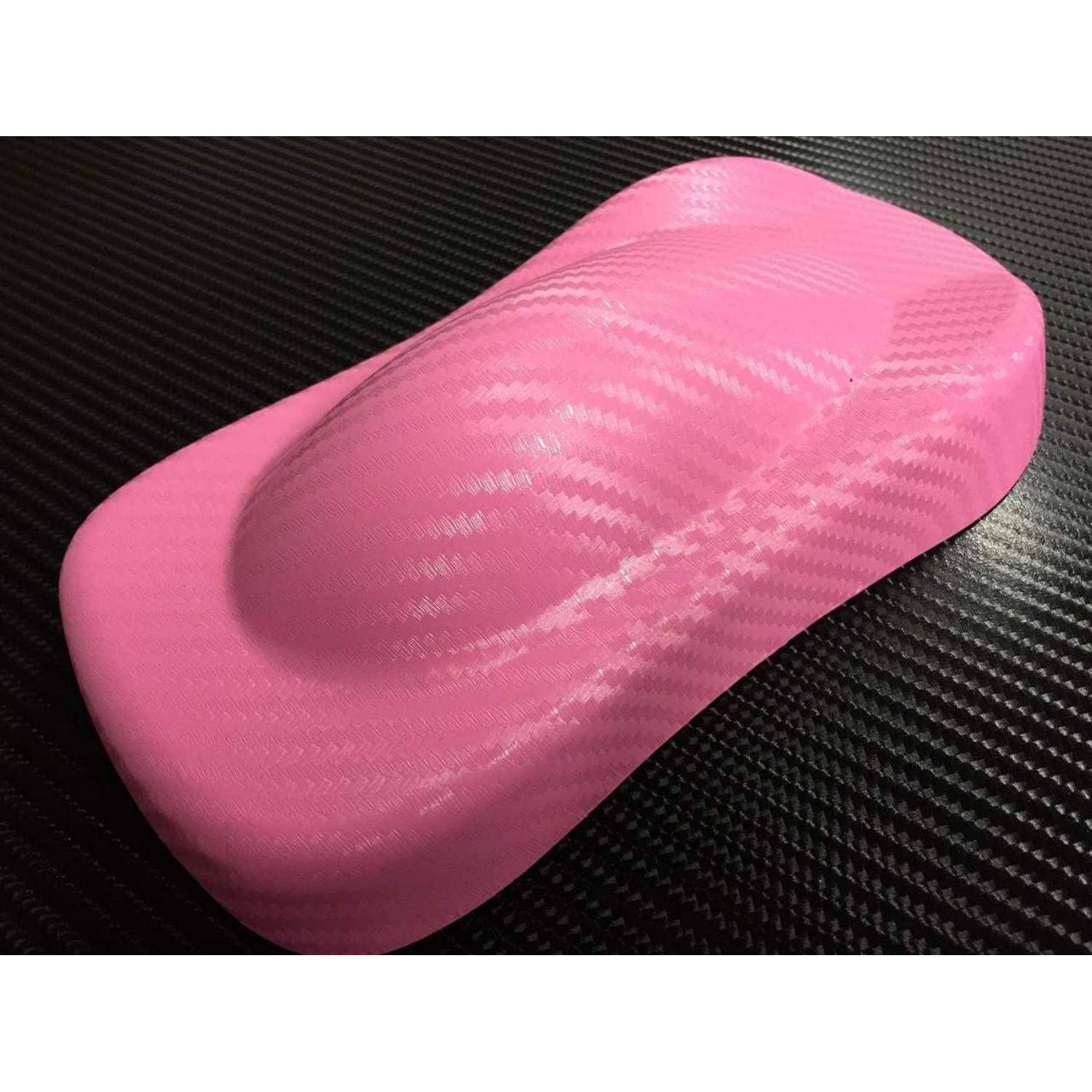 Rosa Autokörperschale oder Modellbauteil mit Kohlefaser-Textur auf einer dunklen Oberfläche, von oben betrachtet.