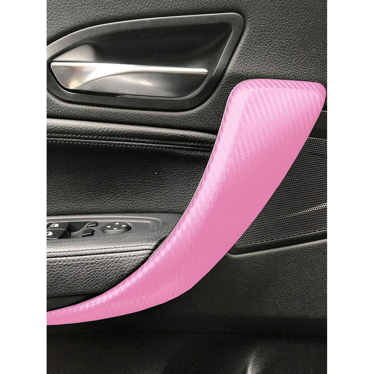 Autotürinnenseite mit hellem rosa benutzerdefinierten Verzierungen oder Griffakzenten über schwarzem Polster und silbernem Türgriff.