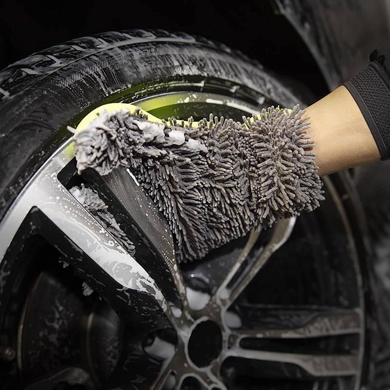 Mikrofaser-Waschhandschuh reinigt eine schwarze Felge eines Autos mit Seife und Wasser während der Reinigung.