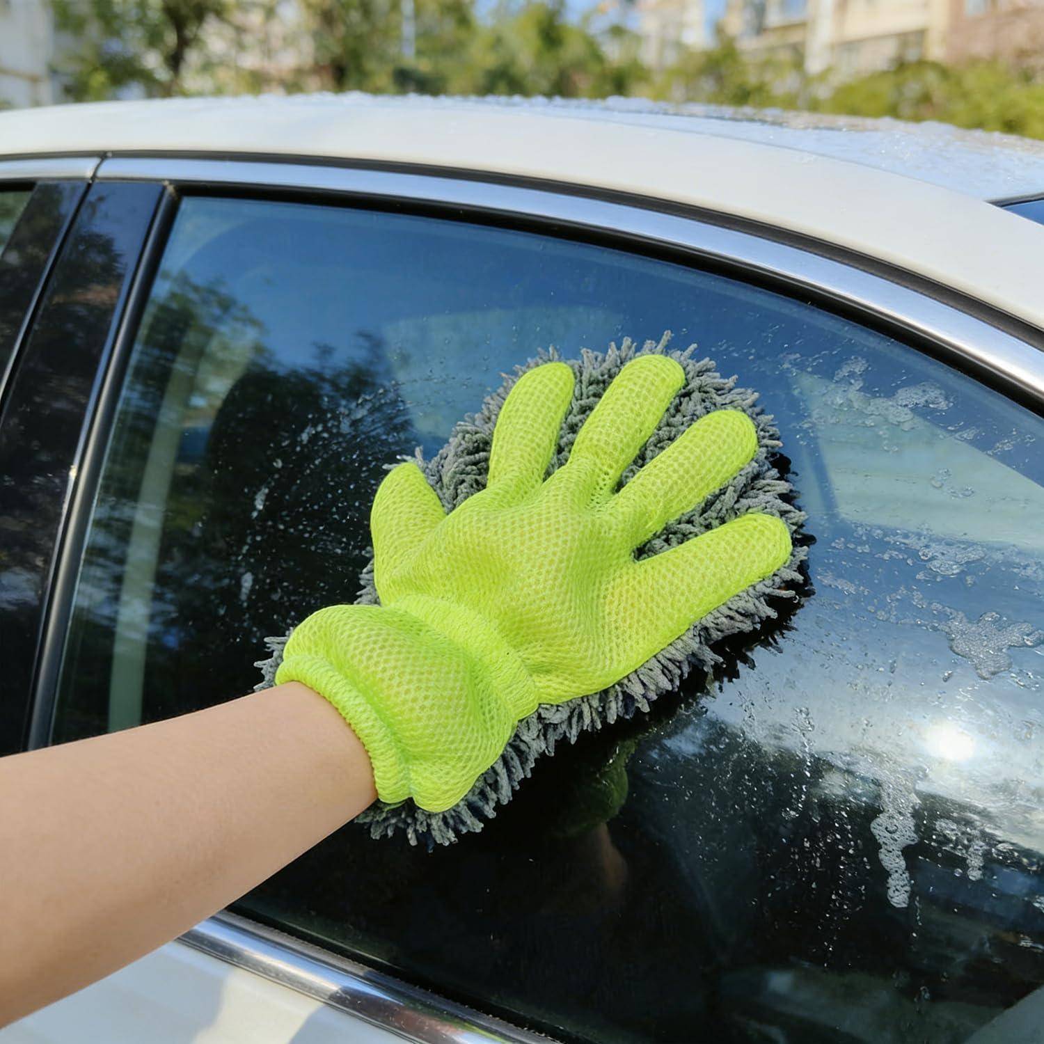 Leuchtend grüne behandschuhte Hand, die ein Autofenster mit einem Mikrofaser-Waschhandschuh abwischt und Reinigungsseife und Wasser vom Glas im Freien entfernt.
