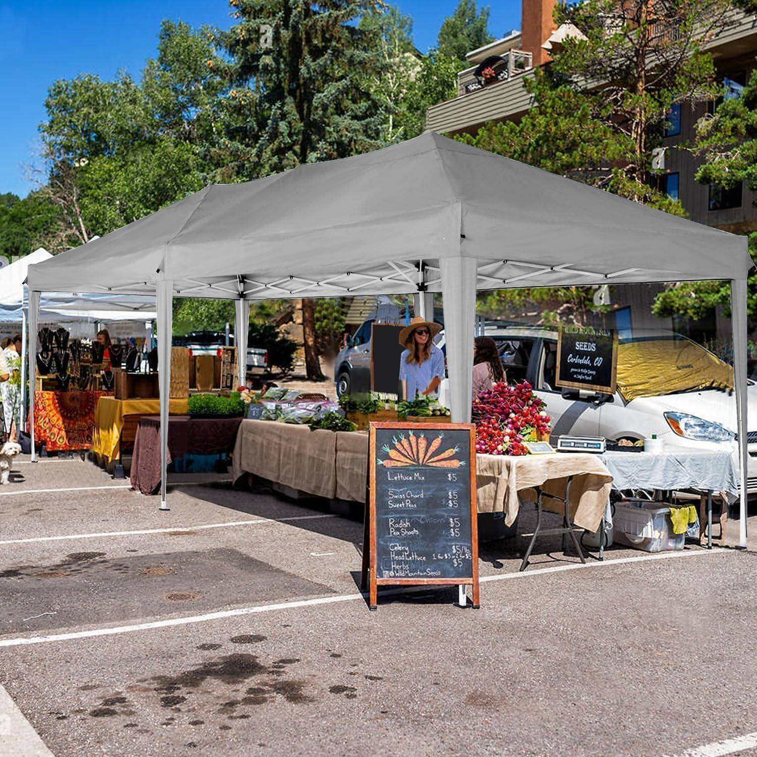 Bäuerlicher Außenmarktstand unter einem weißen Baldachin mit Obst und Gemüse, Blumen und einer Kreidetafel-Preisschild, mit Verkäufern die Kunden bedienen.