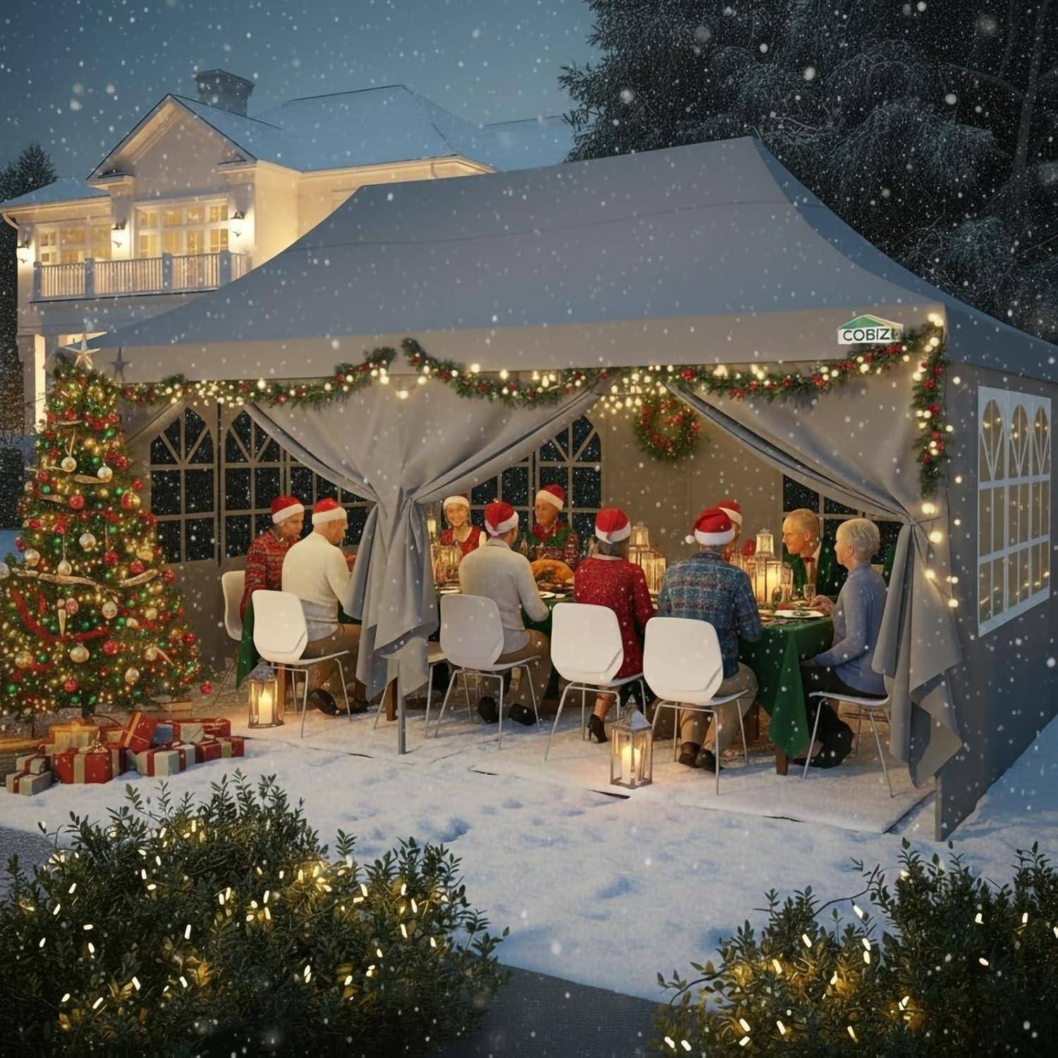 Menschen in Weihnachtsmützen versammeln sich unter einem dekorierten Outdoor-Feierzelt zu einem schneebedeckten Weihnachtsdinner, mit einem leuchtenden Baum und eingepackten Geschenken in der Nähe.