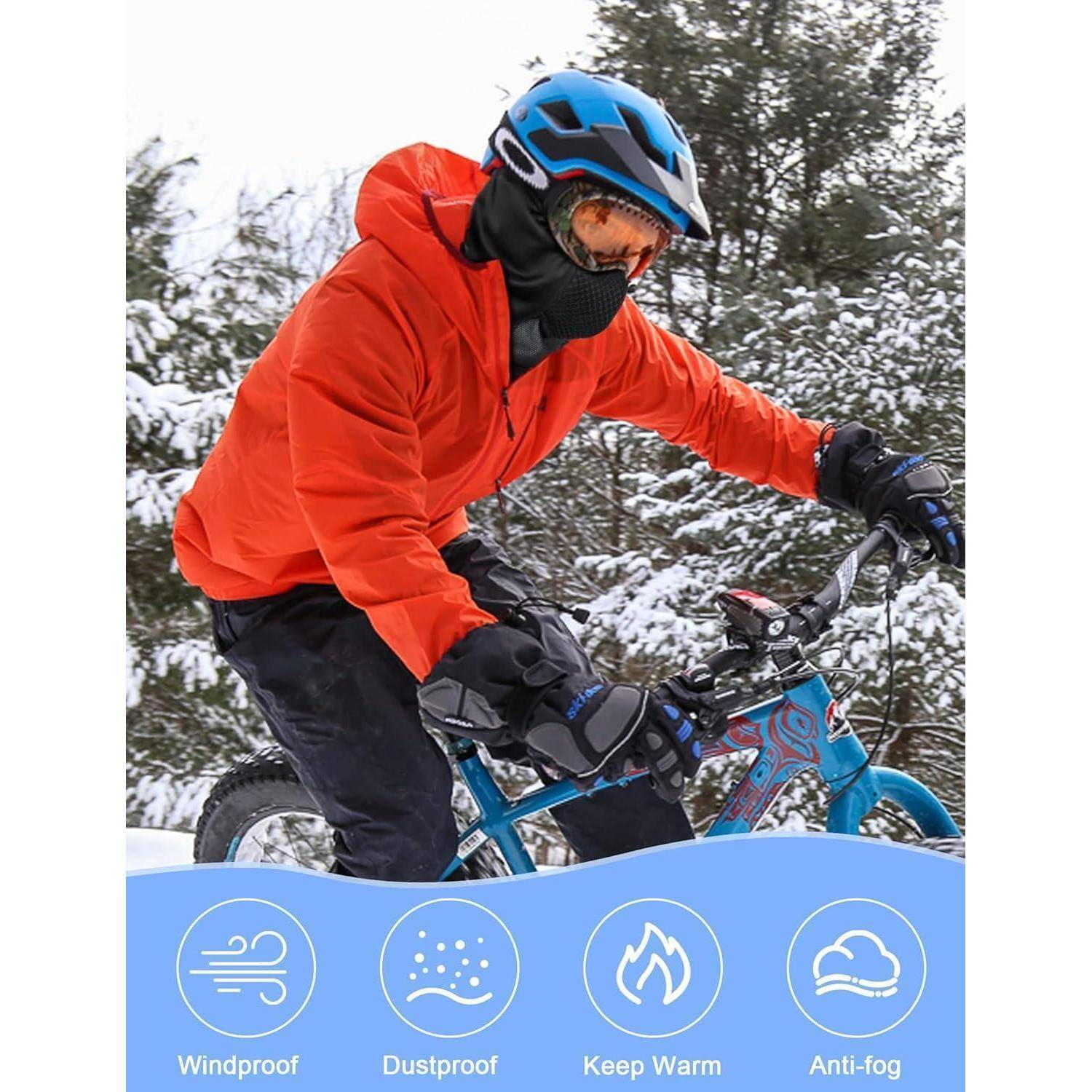 Radfahrer in orangefarbener Jacke und Helm fährt ein blaues Fahrrad in verschneiten Wäldern; die Symbole unten heben winddicht, staubdicht, warm halten und antifog hervor.