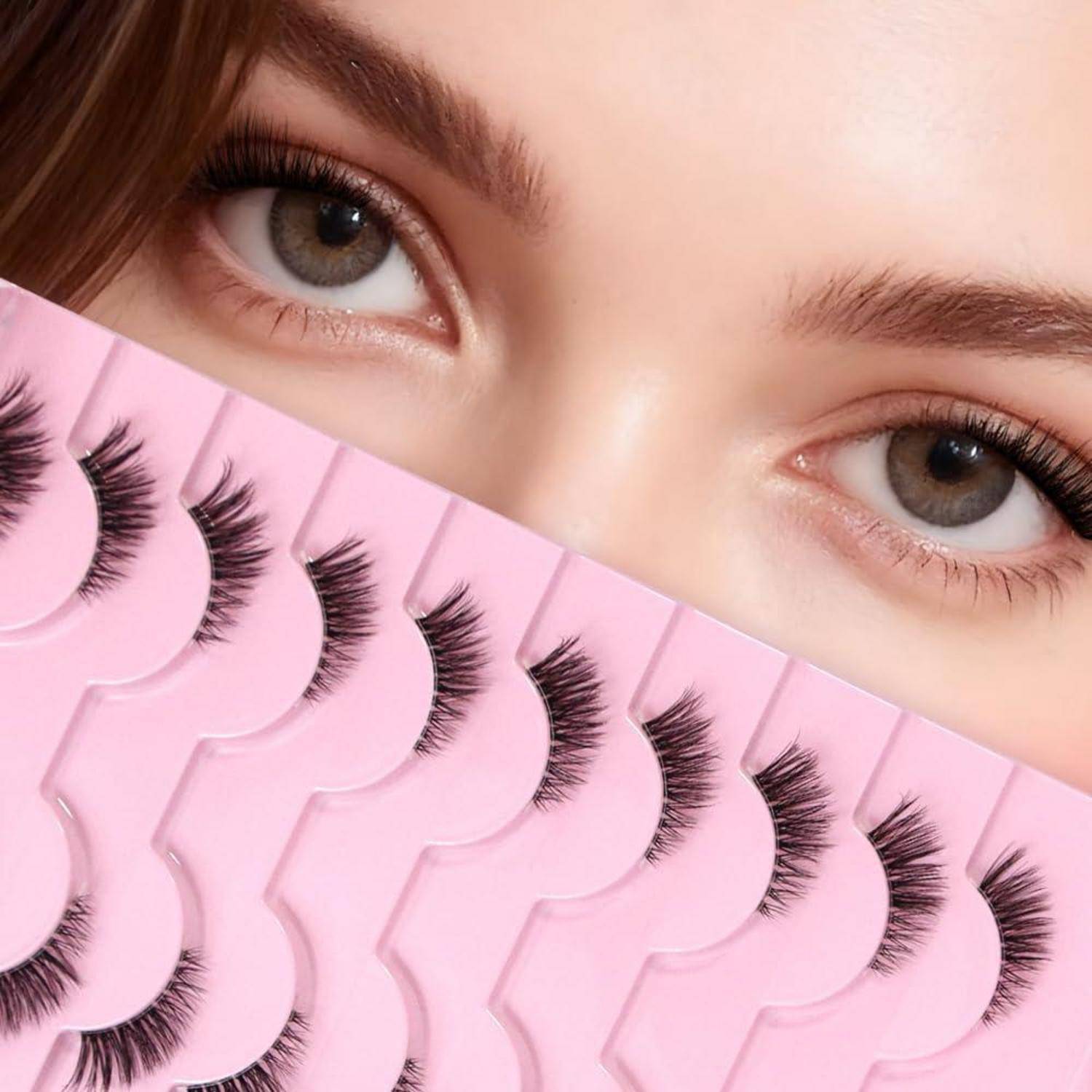 Nahaufnahme der Augen einer Person über rosafarbenen künstlichen Wimpernstreifen, was auf Beauty- oder Kosmetikprodukte hindeutet.