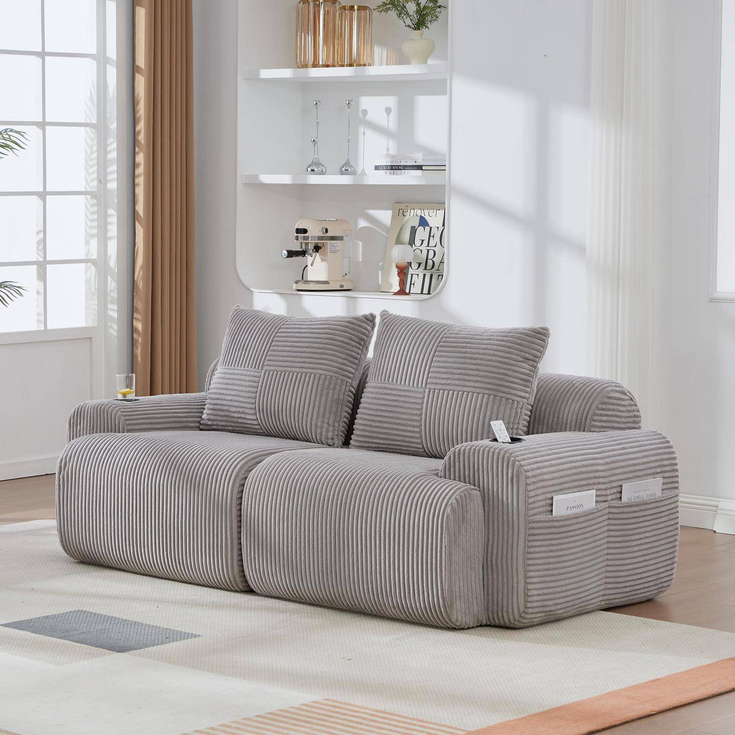 Graues gestreiftes modulares Sofa mit gerundeten Kissen in einem hellen Wohnzimmer, gezeigt auf einem hellen Teppich neben einem Fenster und einem Wandregal.