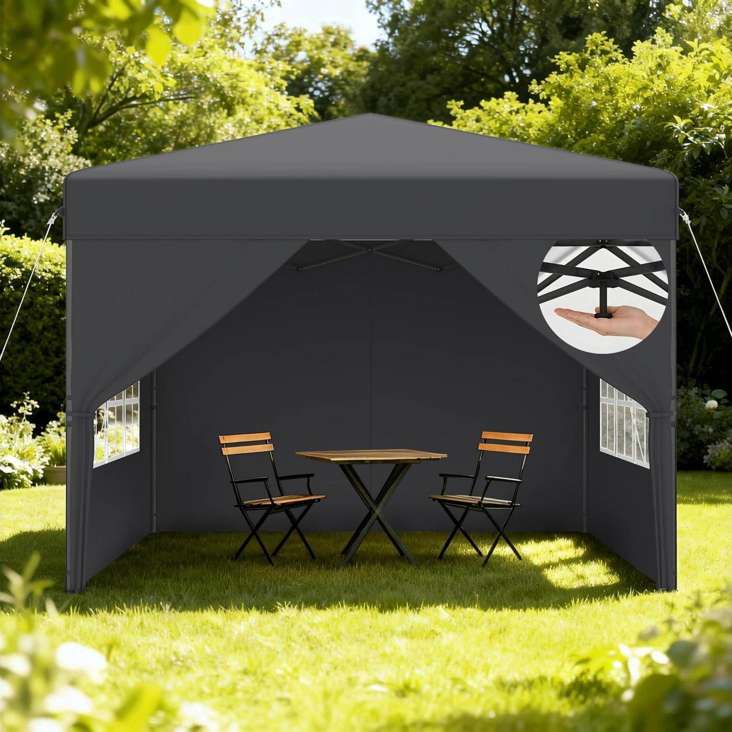 Graues Outdoor-Popup-Zelt mit zwei Klappstühlen und einem kleinen runden Tisch auf Gras; Nahaufnahme zeigt eine Hand, die den Rahmen verstellt.