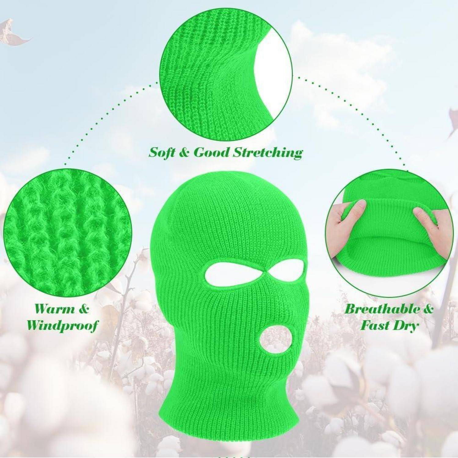 Leuchtend grüne gestrickte Sturmmaske mit Augen- und Mundöffnungen, dargestellt mit Beschriftungen, die weiches, dehnbares Material, Wärmeisolation, Windschutz und Atmungsaktivität hervorheben.