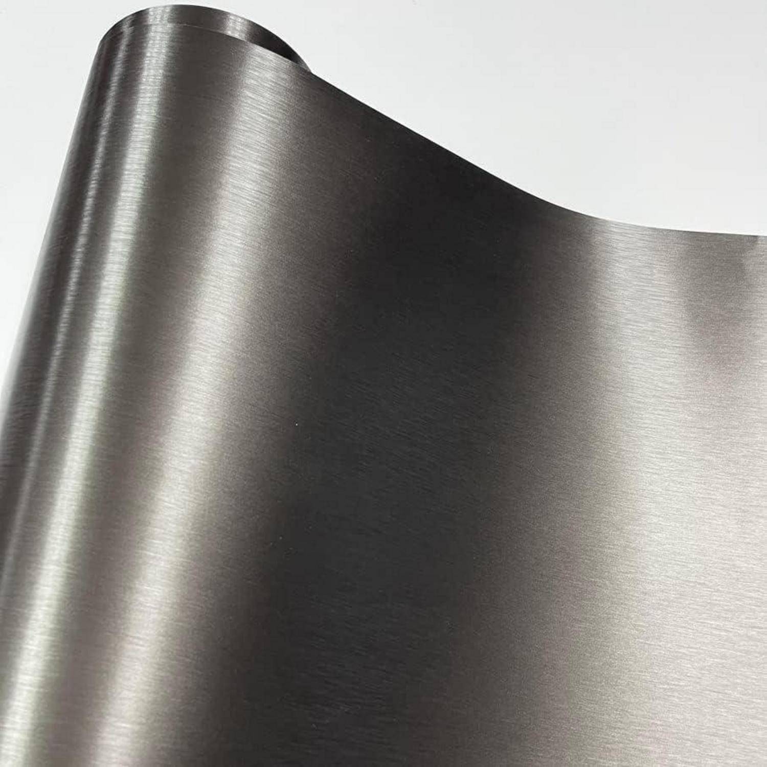 Nahaufnahme eines gebürsteten Edelstahlblechs mit einer gerollten gewölbten Kante und reflektierender metallischer Oberfläche.
