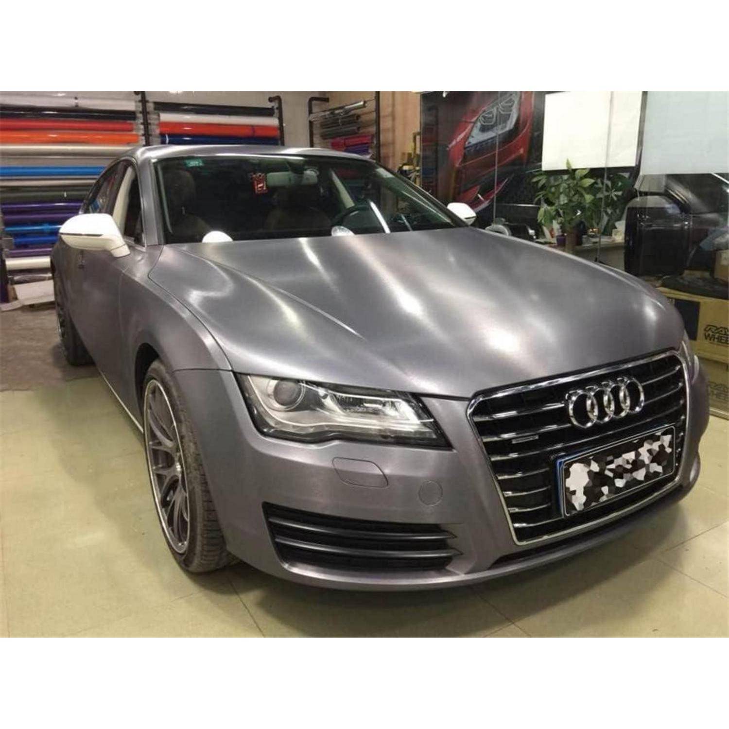 Frontansicht einer silbernen Audi-Limousine, die in einem Innenbereich geparkt ist und den Kühlergrill, die Scheinwerfer und den vorderen Kennzeichenbereich zeigt.