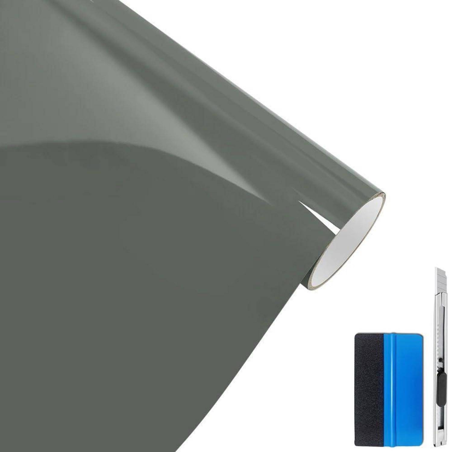 Rolle mit grauem Fensterfilm neben einem blau-schwarzen Universalmesser auf weißem Hintergrund.
