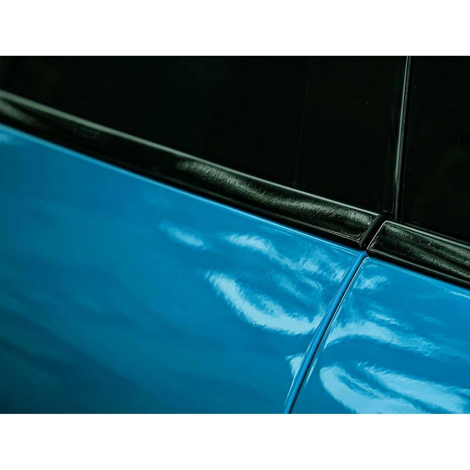 Nahaufnahme einer blauen Autotür und schwarzer Fenstereinfassung, die reflektierende Lackierung und eine Panelnaht zeigt.