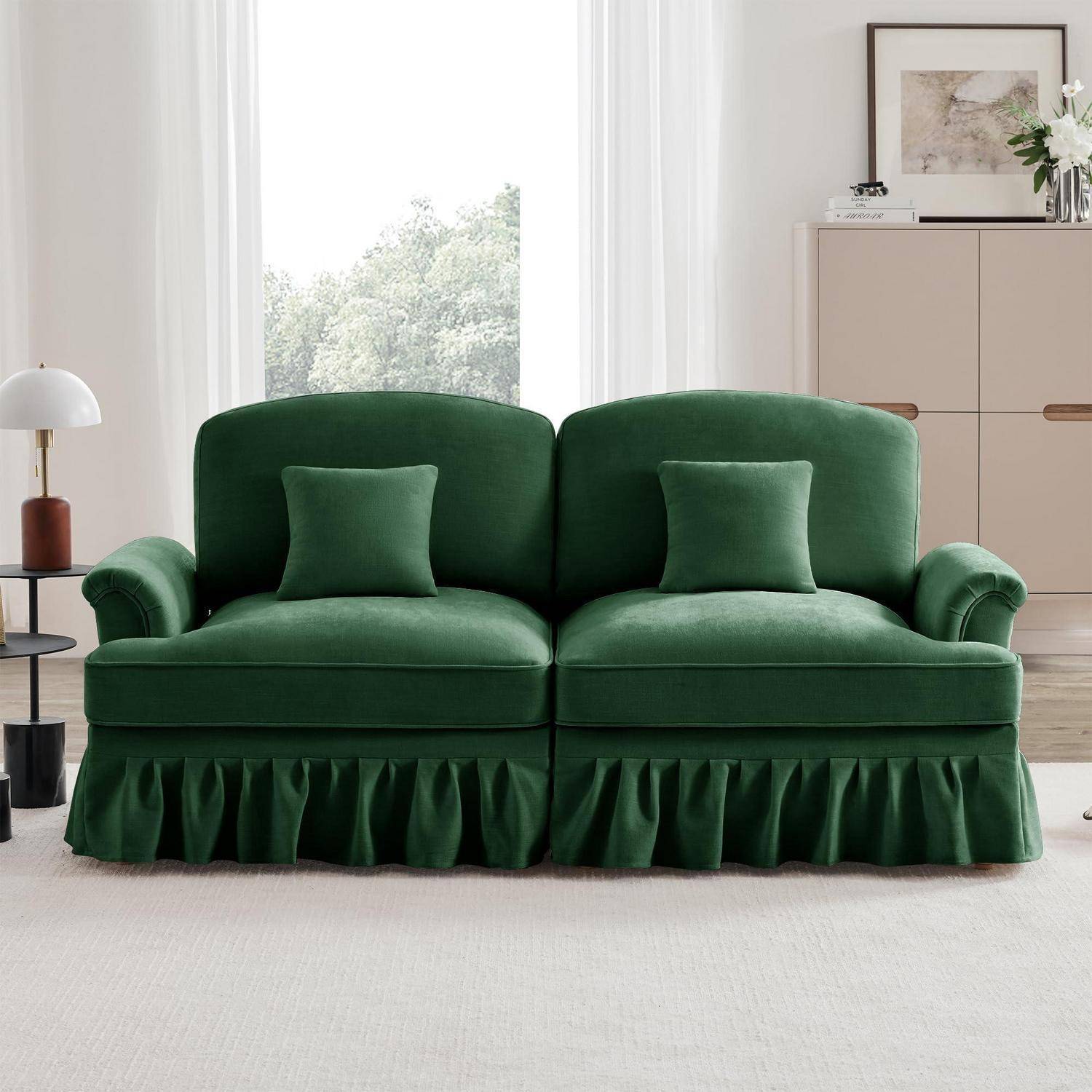 Grünes Samtliebessitz-Sofa mit zwei passenden Kissen und gerüschtem Saum in einem hellen, modernen Wohnzimmer