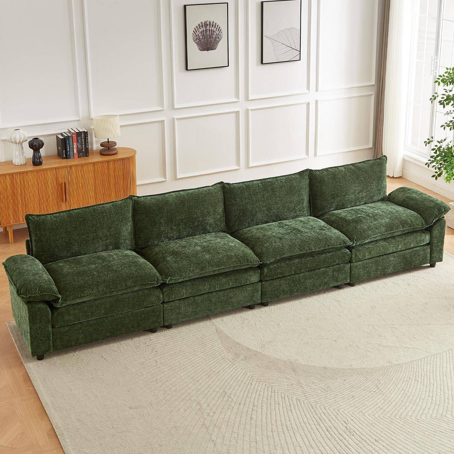 Grünes Samtcorner-Sofa in einem hellen Wohnzimmer, gezeigt auf einem hellen Teppich mit Wandkunst und einem Holzschrank dahinter.