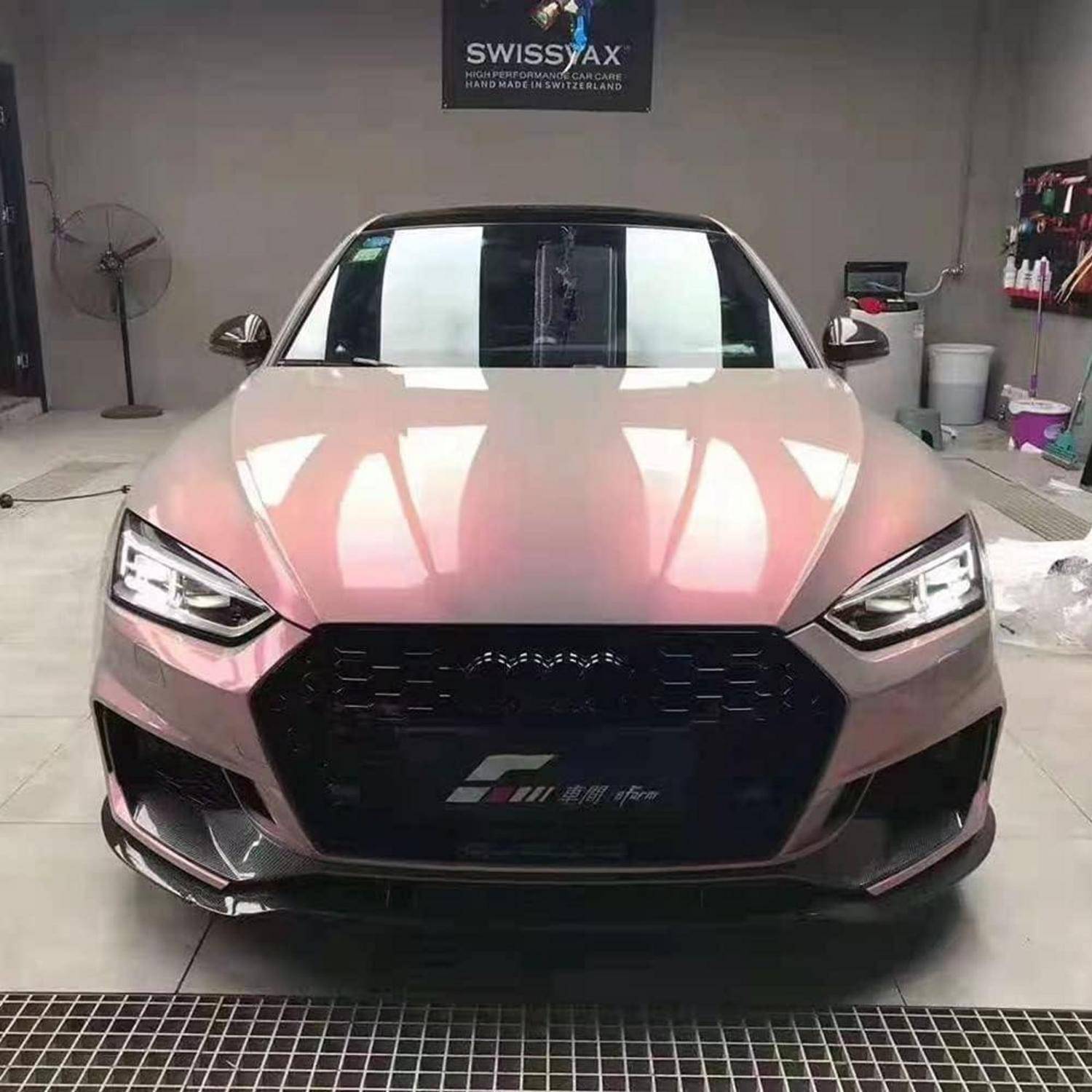 Vorderansicht eines rosa Audi Sportwagens in einer Garage mit einem schwarzen Kühlergrill und scharfsinnigen LED-Scheinwerfern.