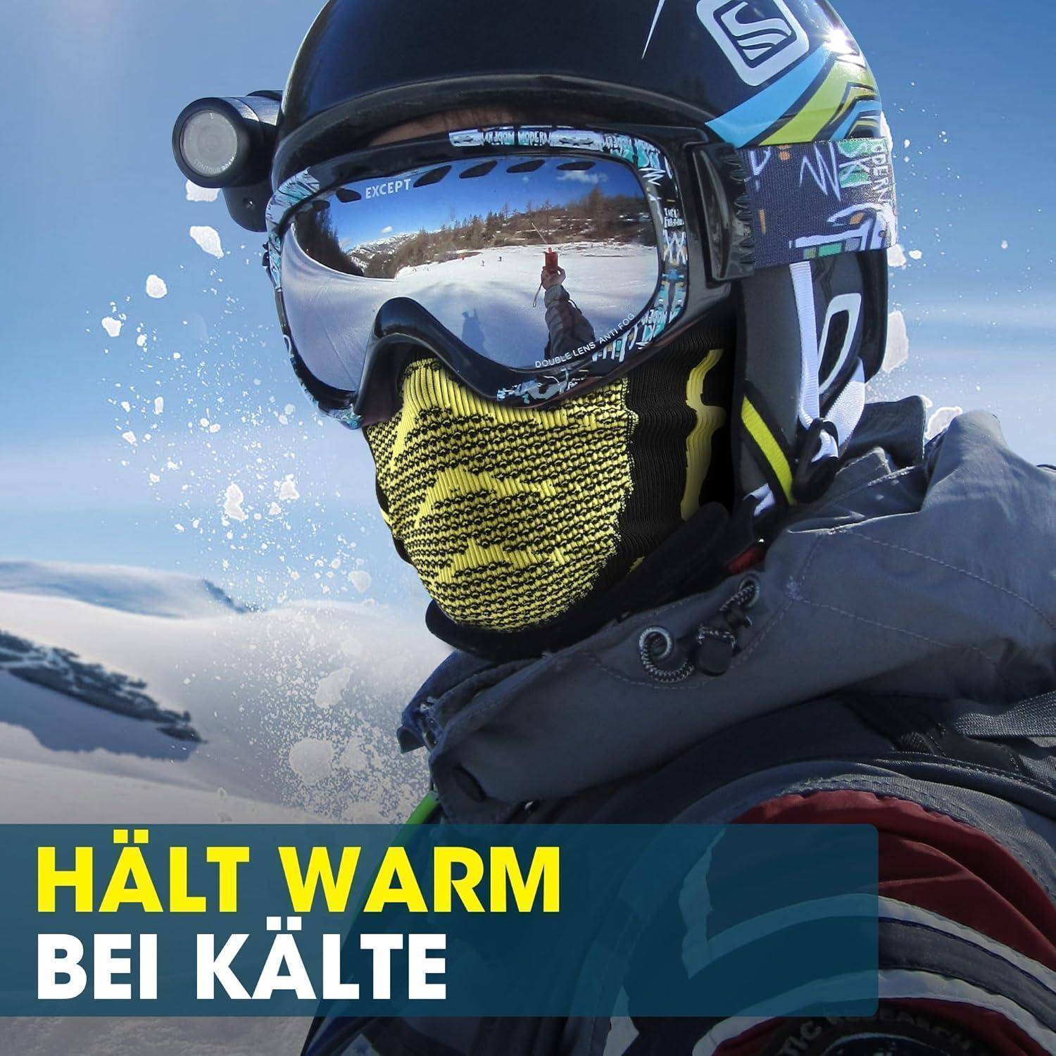 Nahaufnahme einer Person mit Schneehelm, Schutzbrille und Gesichtsschutz in verschneiten Bergen; Text sagt „HÄLT WARM BEI KÄLTE