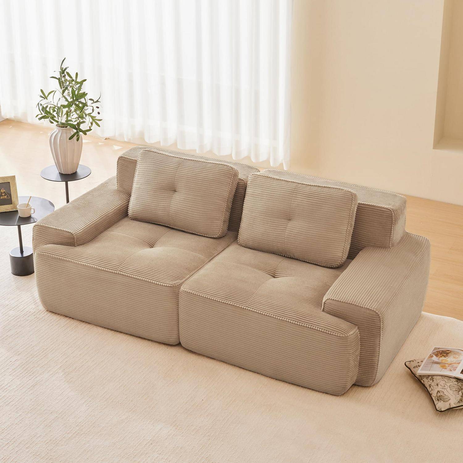 Beige-Kordsofa mit modularem Design, zwei Sitzplätzen und Kissen in einem hellen, minimalistischen Wohnzimmer.
